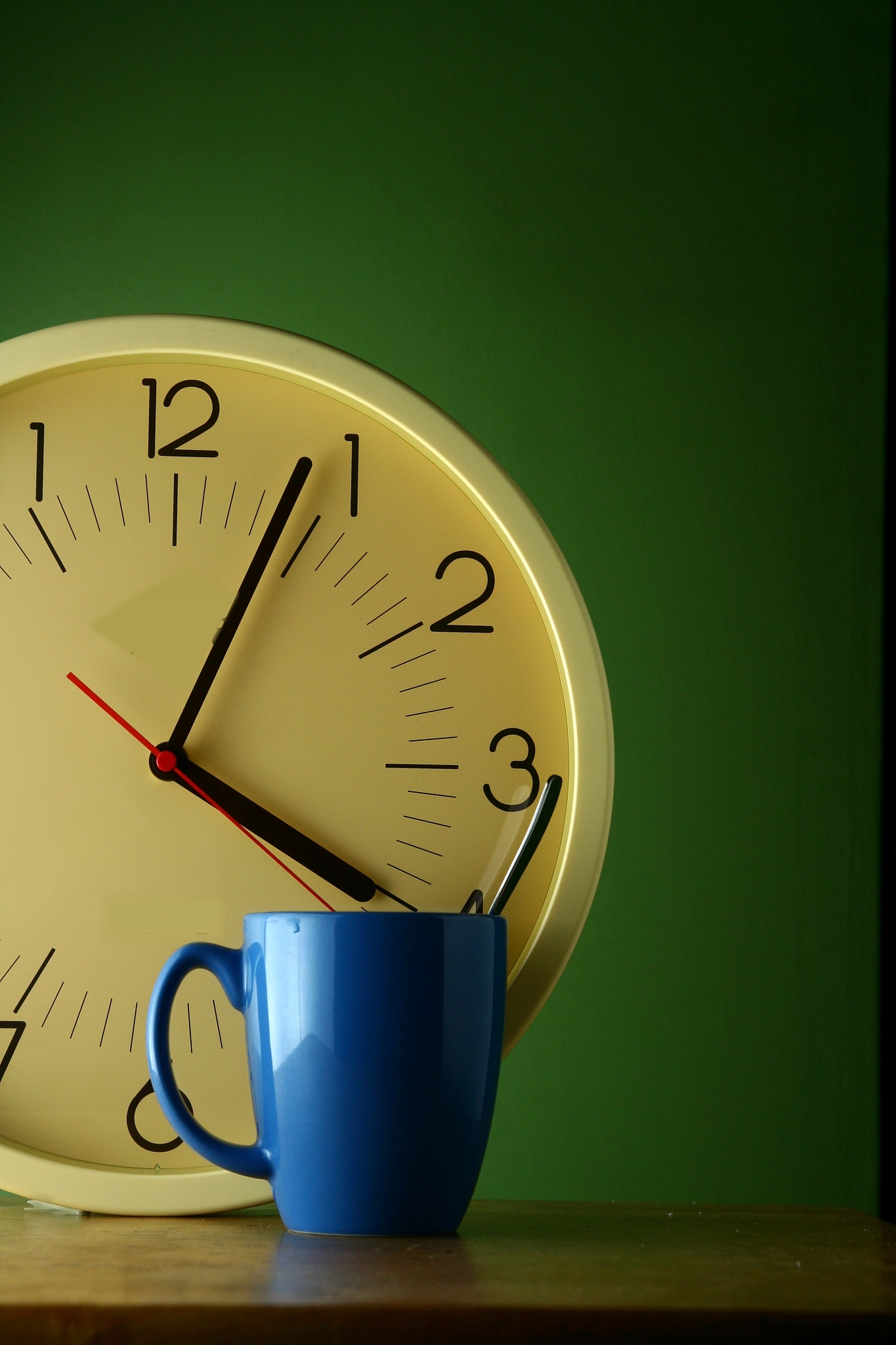 an analog clock and a blue coffee mug