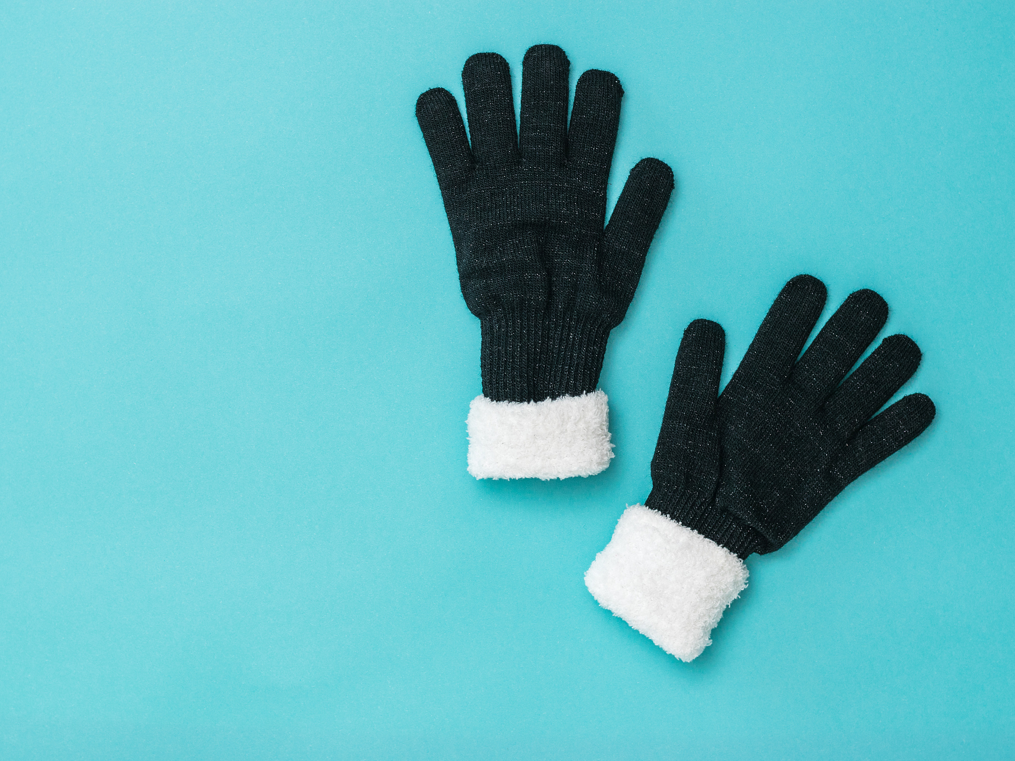winter knitted women's gloves with fur on a blue background. fla