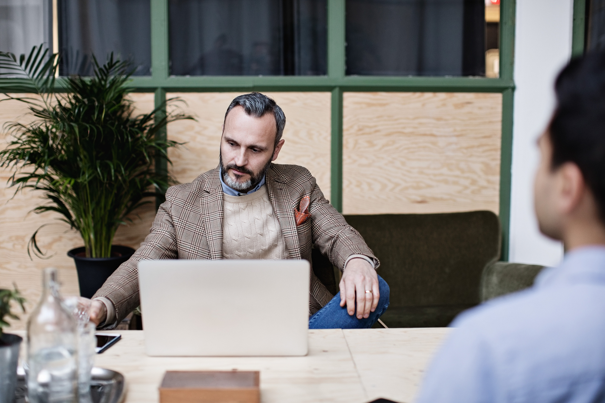 businessman with laptop sitting at table in office