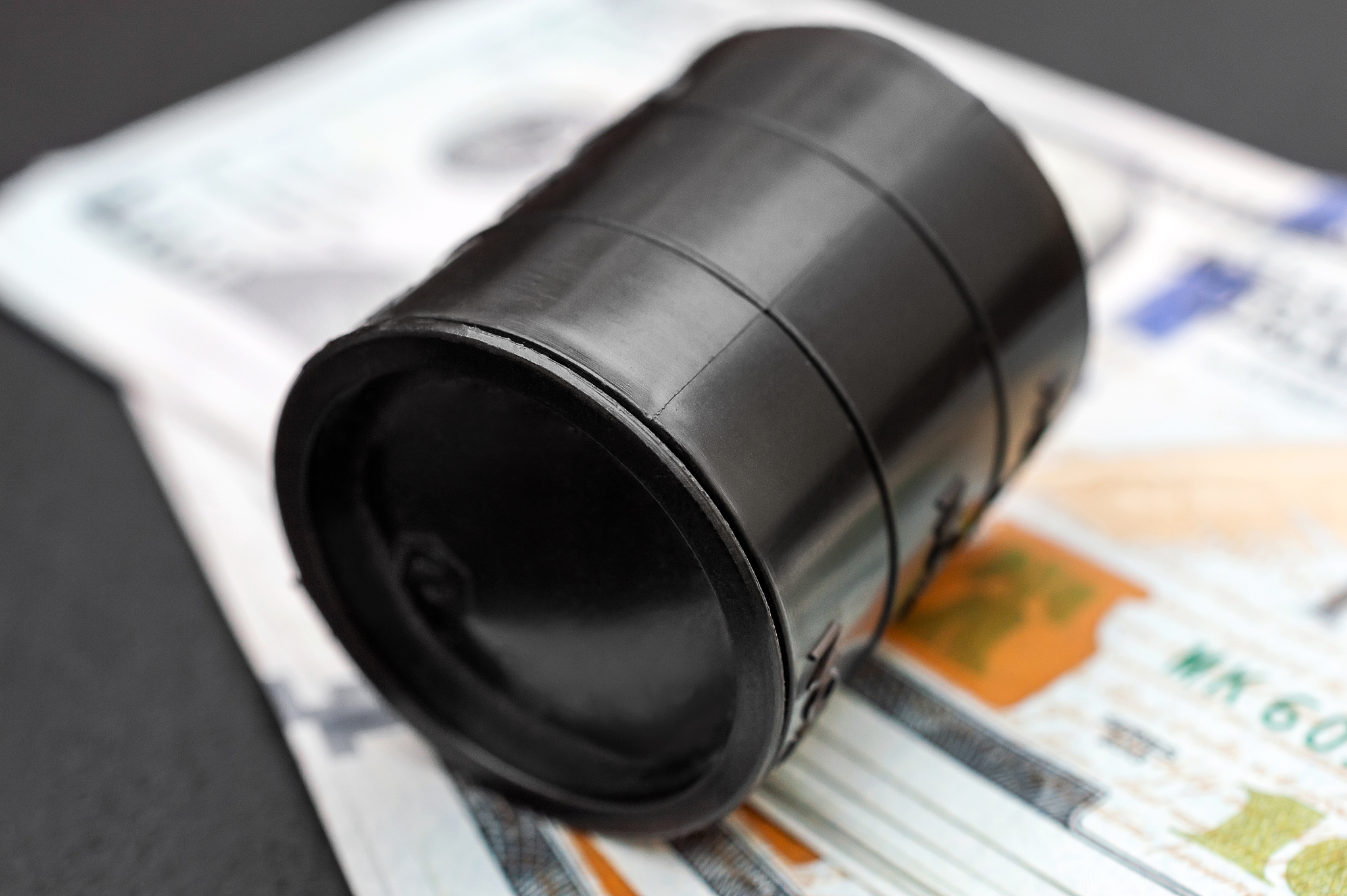 barrel of crude oil on dollars bills. close up. business concept