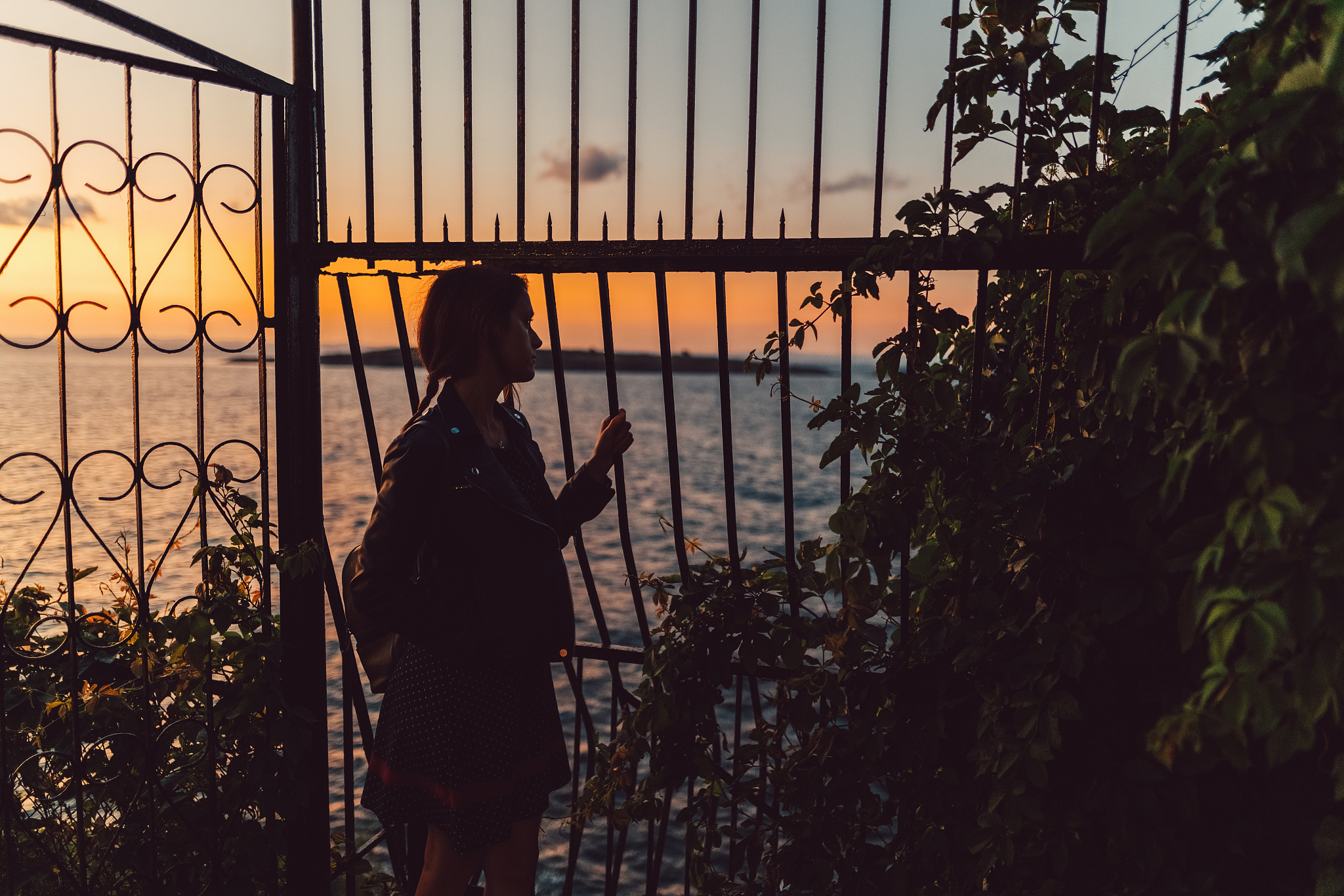 young woman staring the sea at sunset