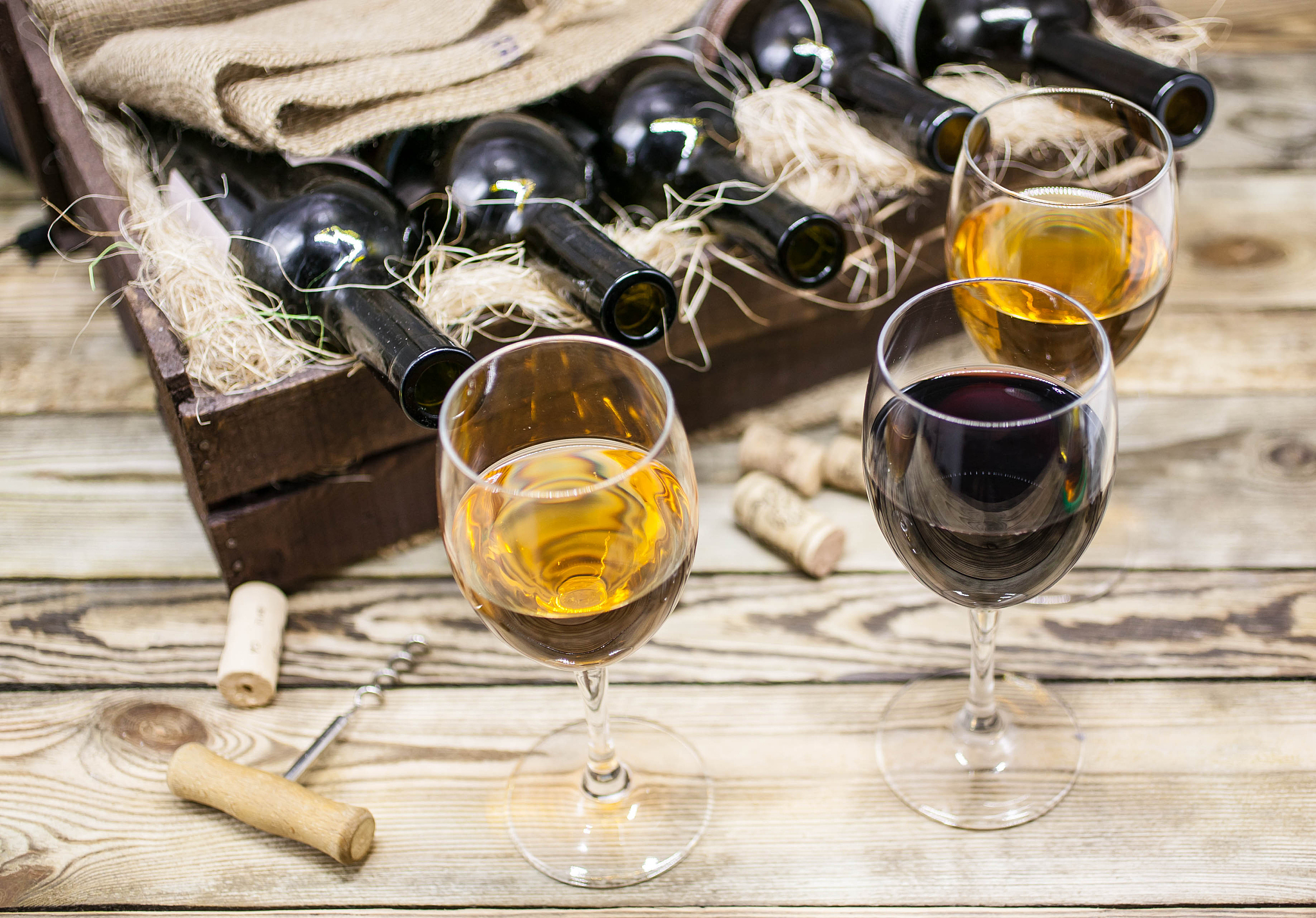 three glasses of wine on a wooden table. wine of a new harvest b