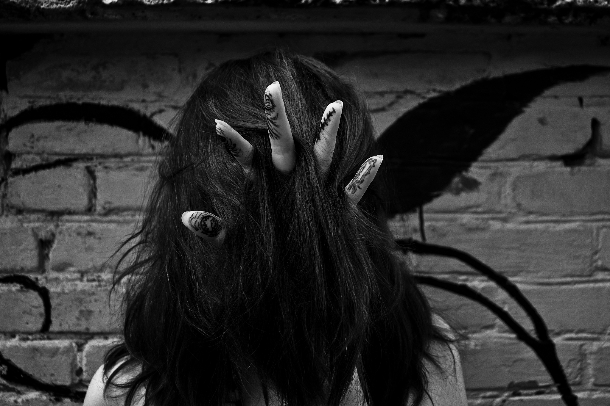 close up of woman with black hair against wall