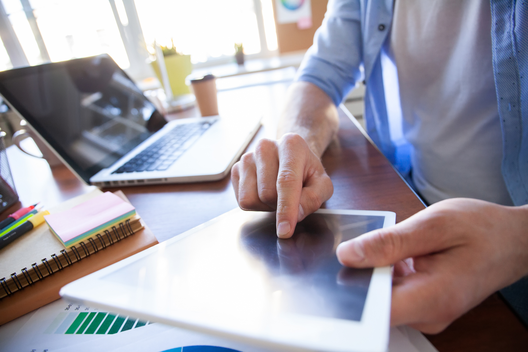close up hands of man touching tablet, multitasking on screen in