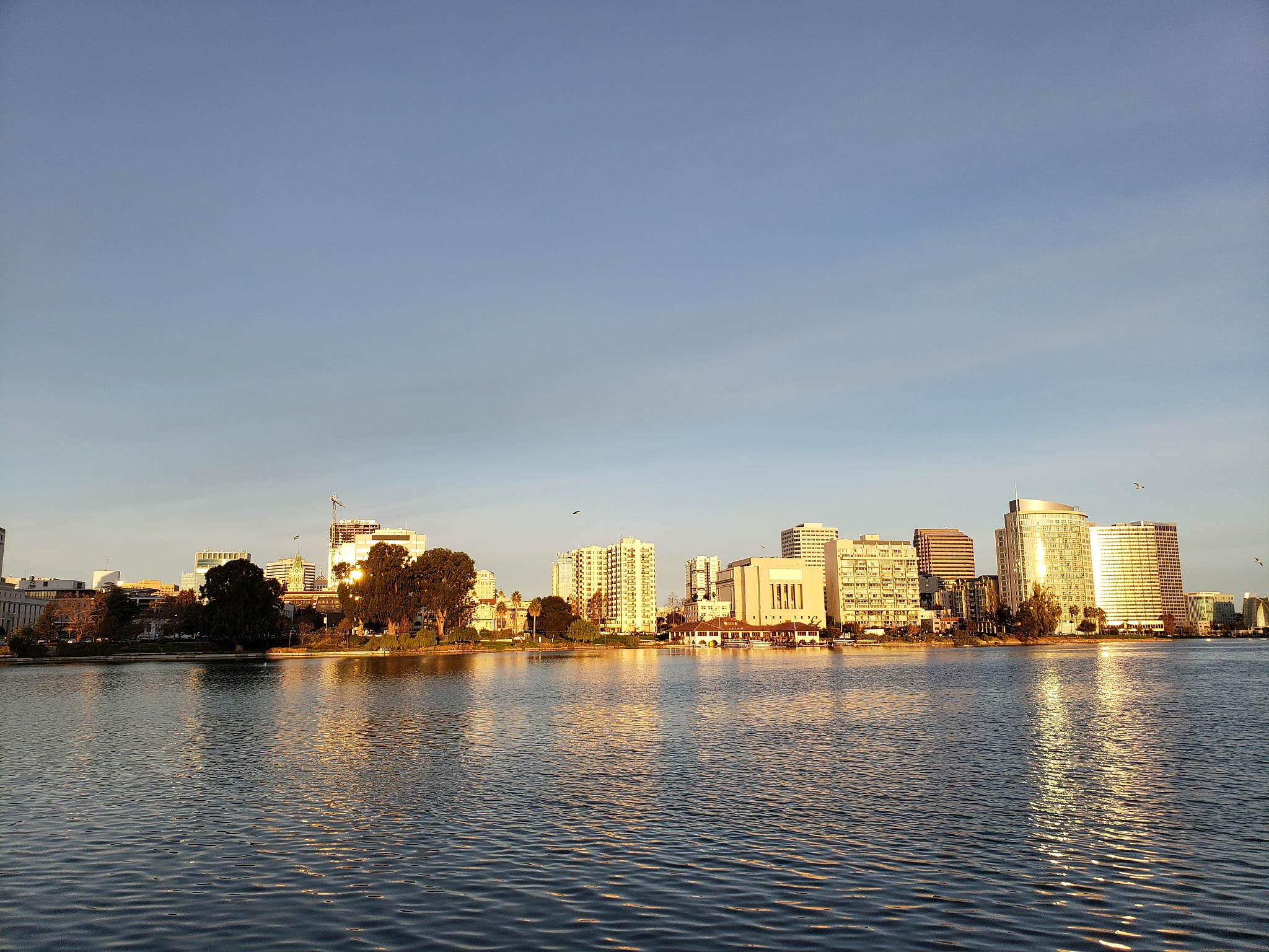 river by buildings in city against sky during sunset