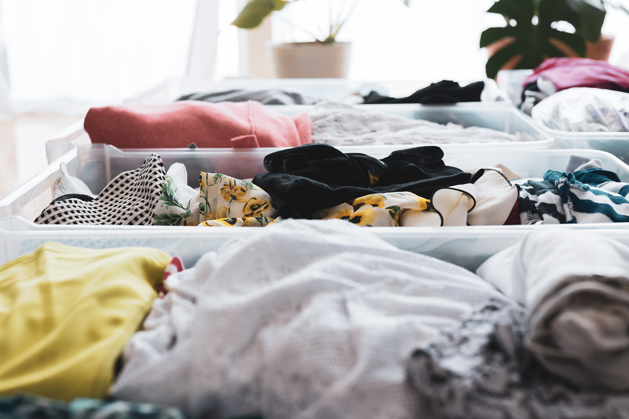 woman organizes clothes in living room of her home