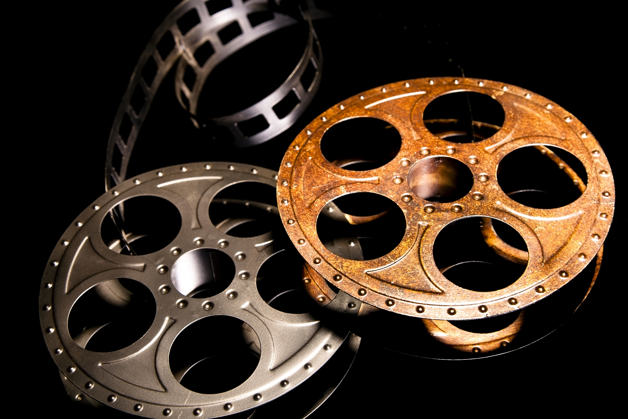 two movie reels and film on black background