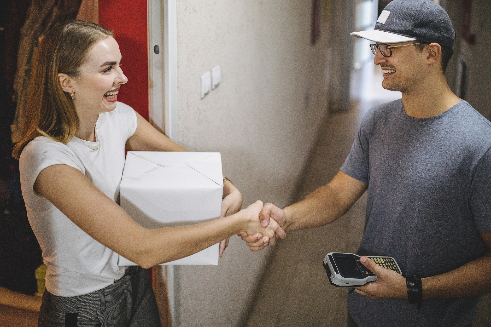 lovely girl and a postal worker handshaking while exchanging pac