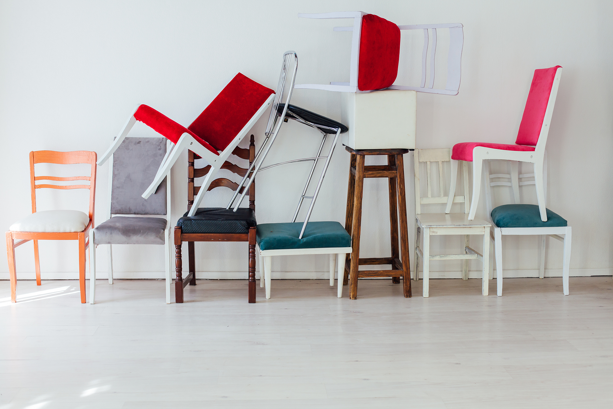 many multicolored chairs stand in the white room