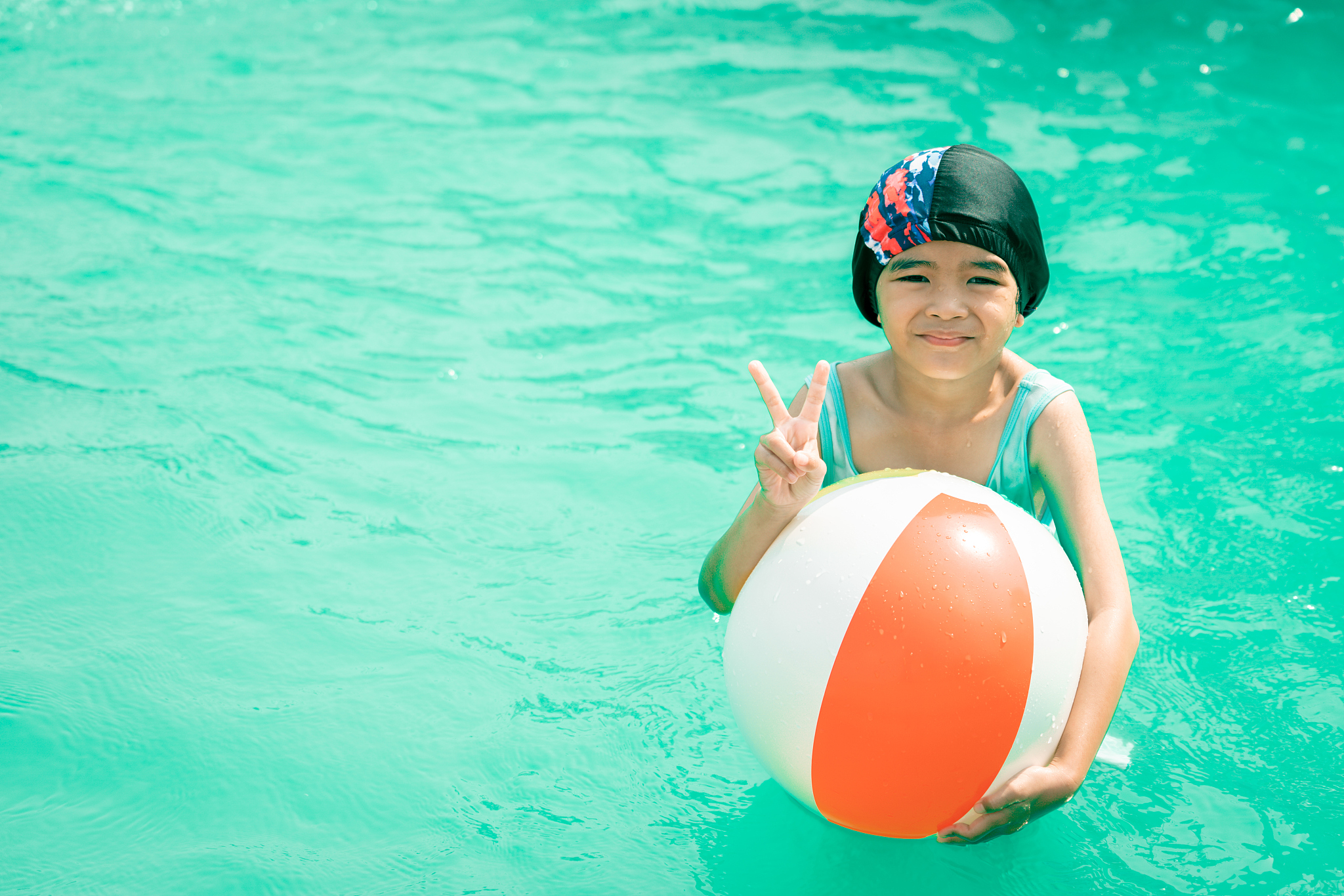 happy kids playing and swimming in swimming pool on summer holid