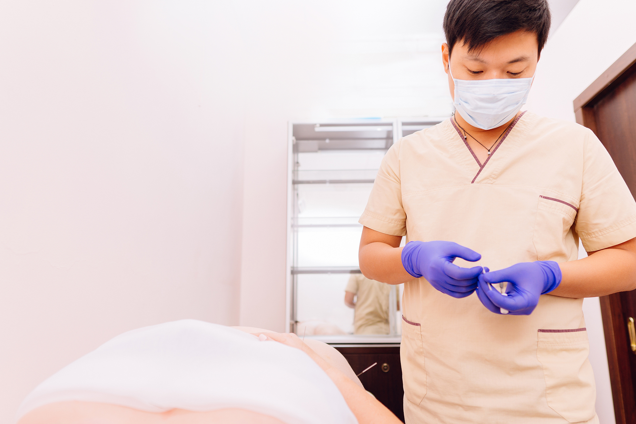 young woman getting acupuncture treatment