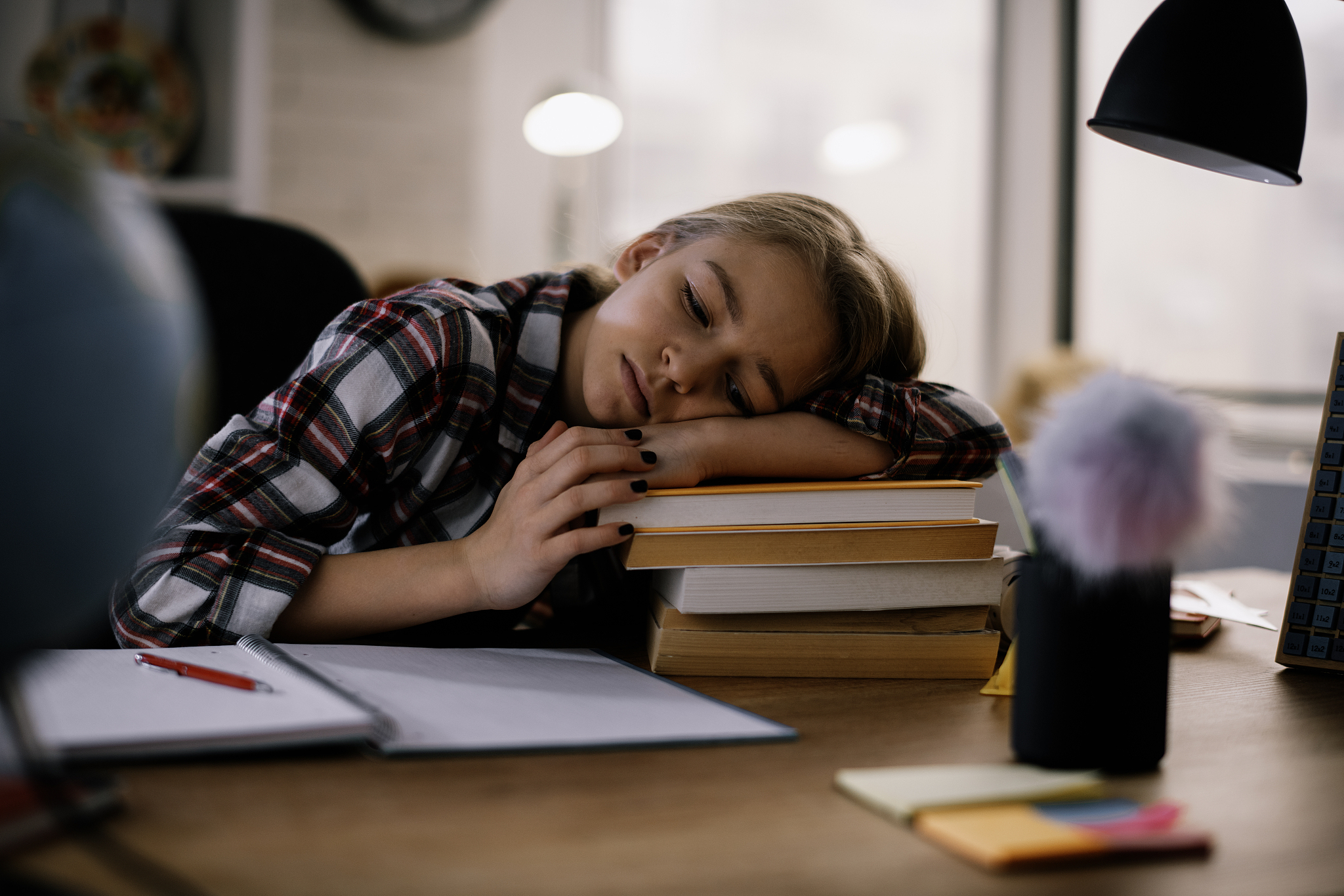 tired little girl doing homework at her desk.