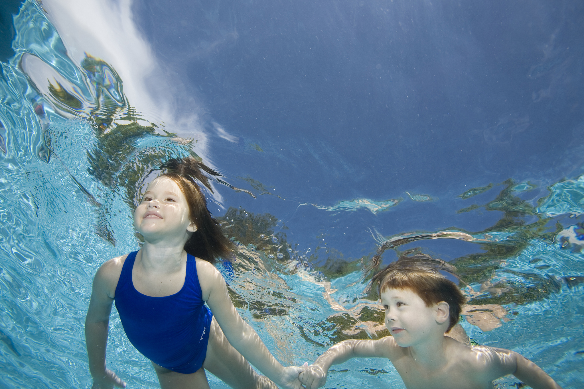 siblings swimming in swimming pool