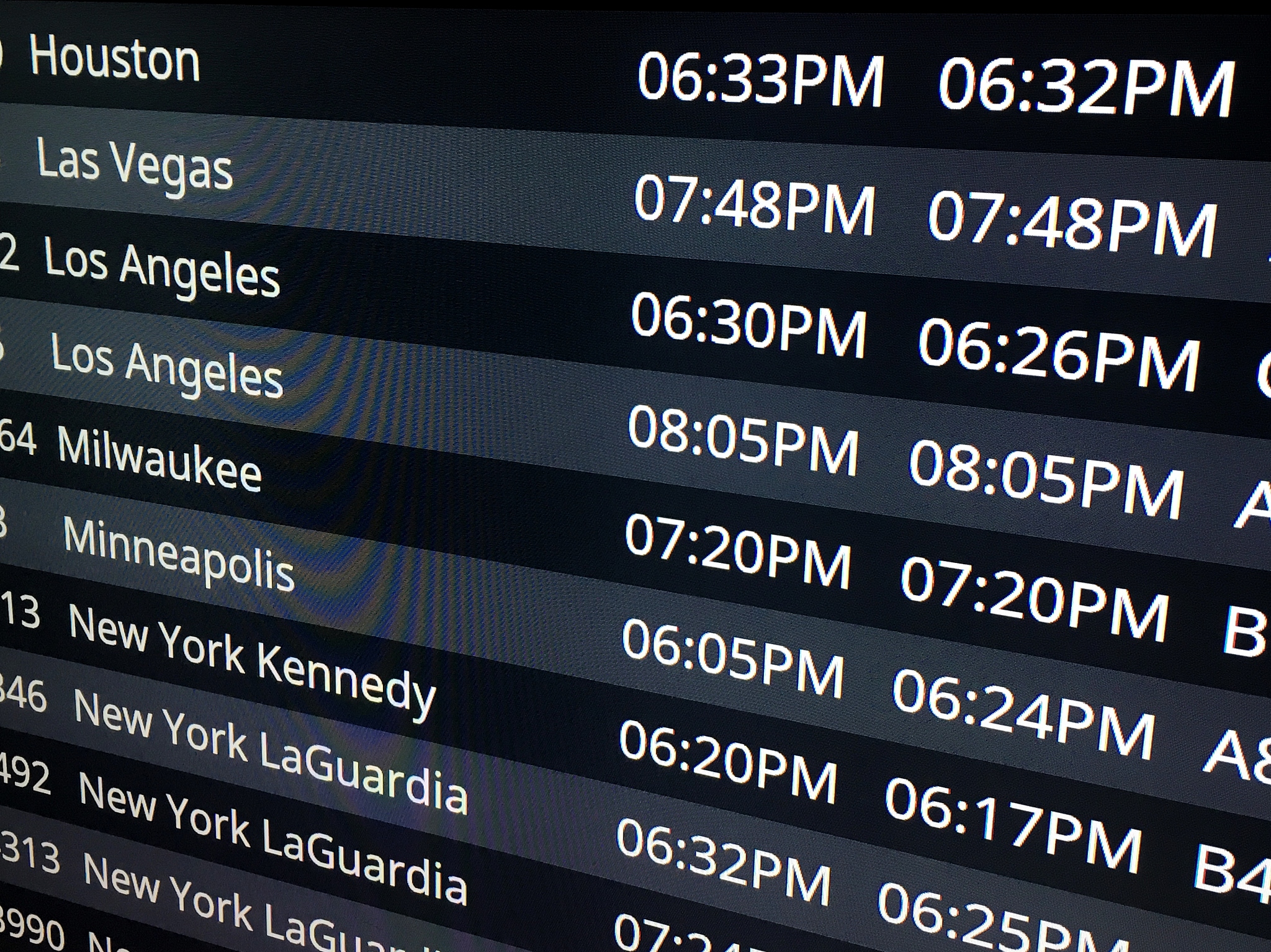 digital arrival board displaying flight times at an airport conc