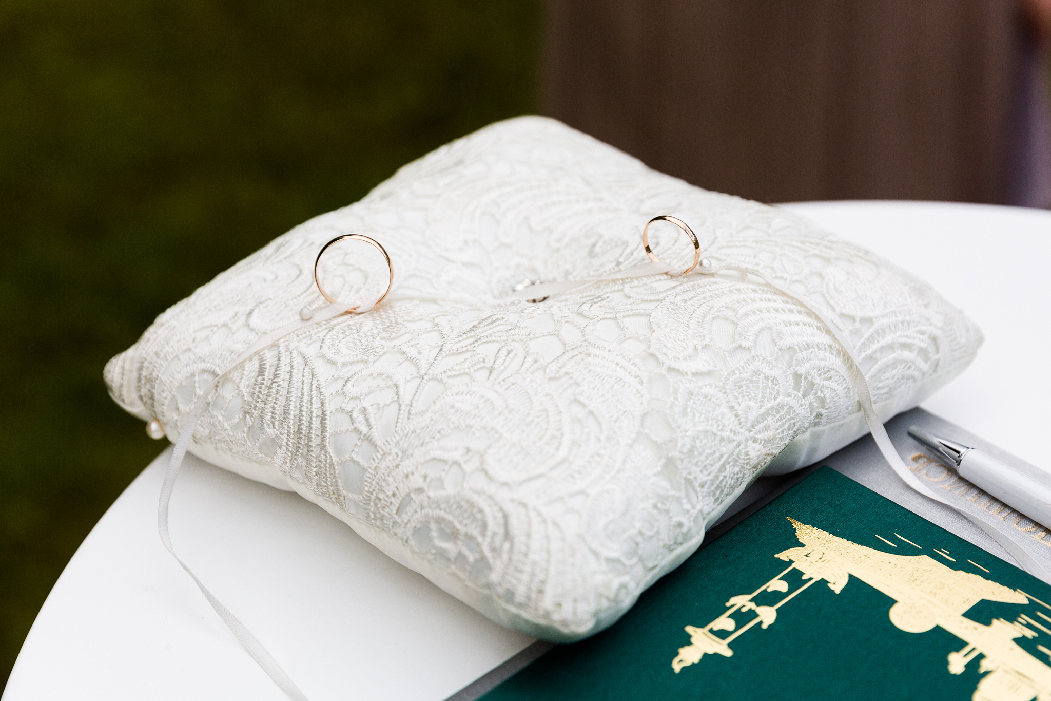 a pair of wedding rings on a white pillow