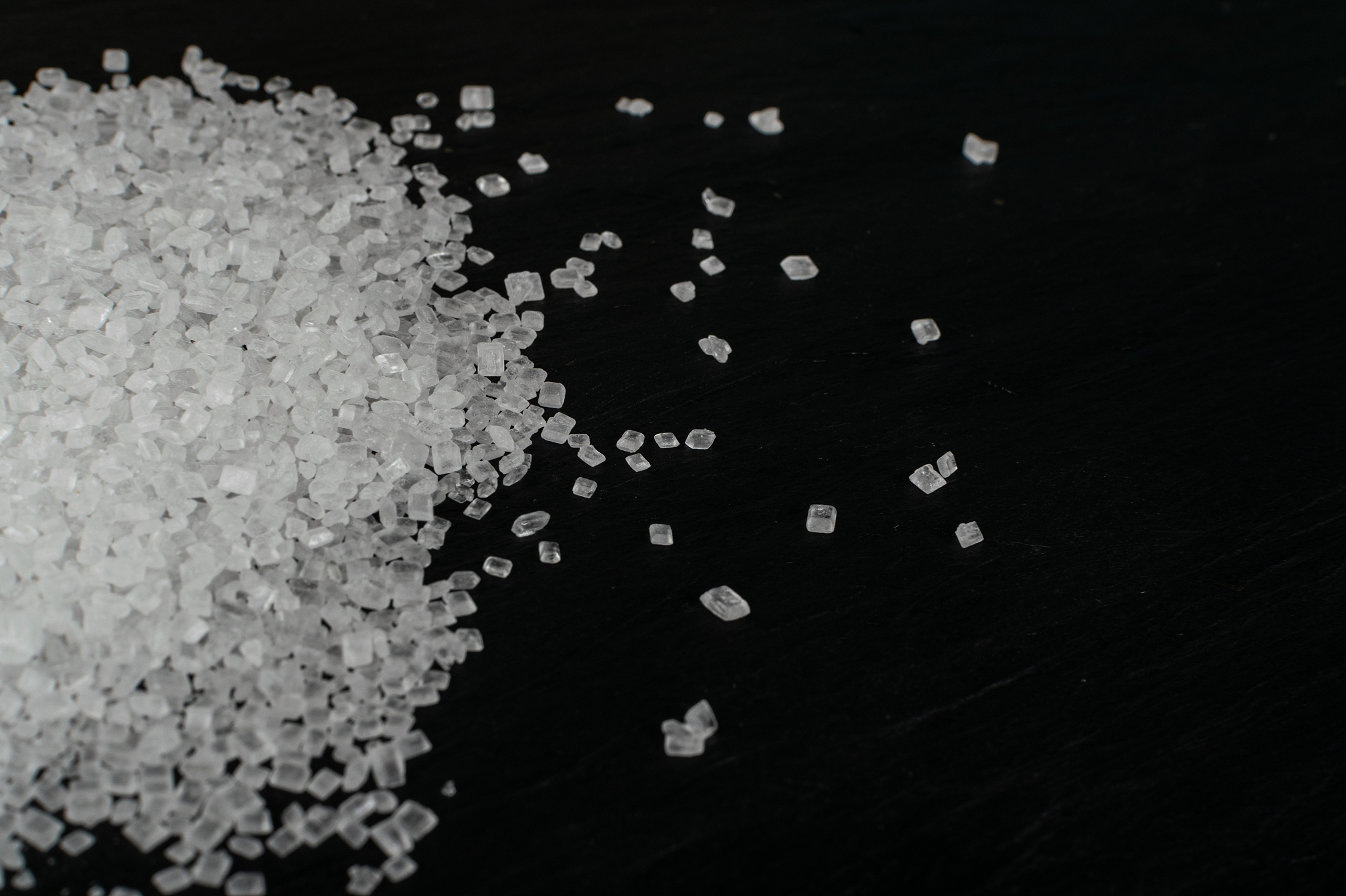 big sugar crystals or sucrose crystals on black background