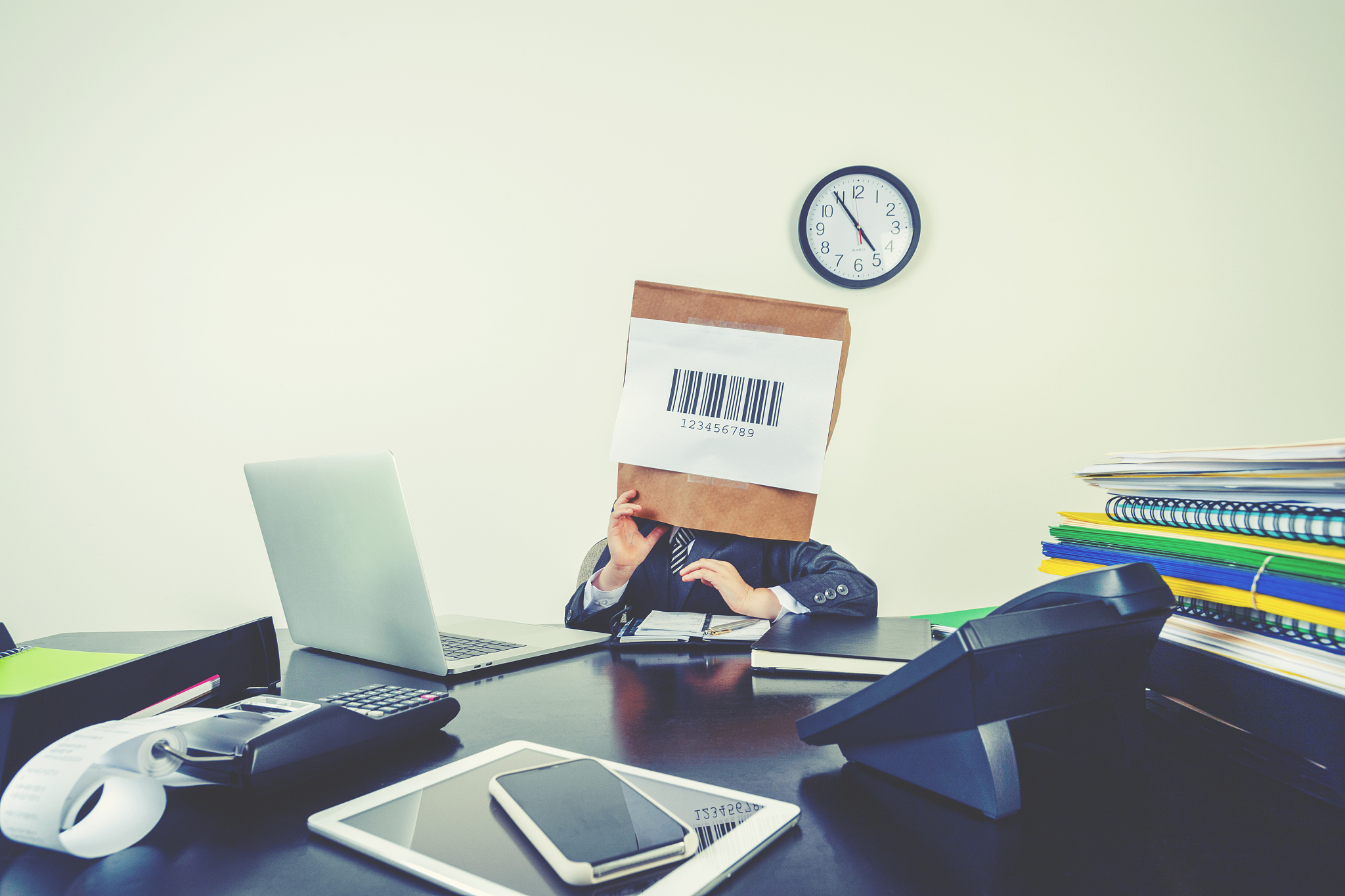 young boy in a business suit with a barcode bag on his head.