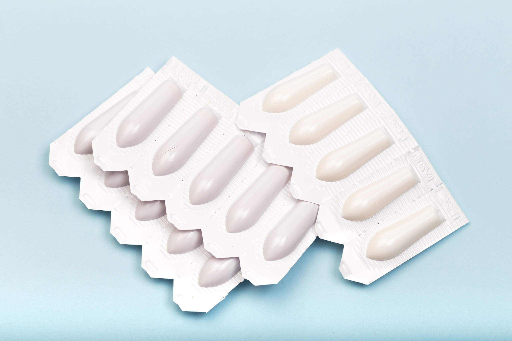 plastic packs of suppositories on blue  background - image