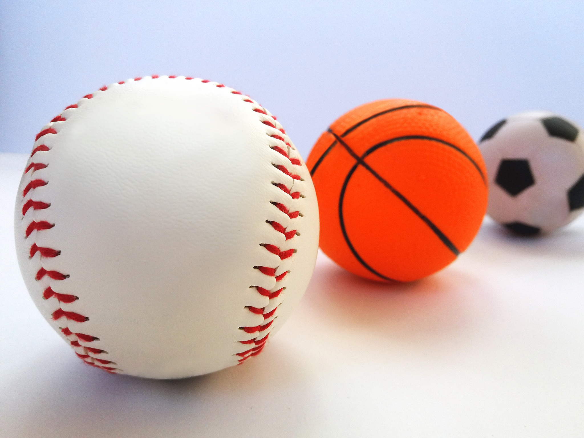 baseball, football, basketball. three sports balls on a light ba