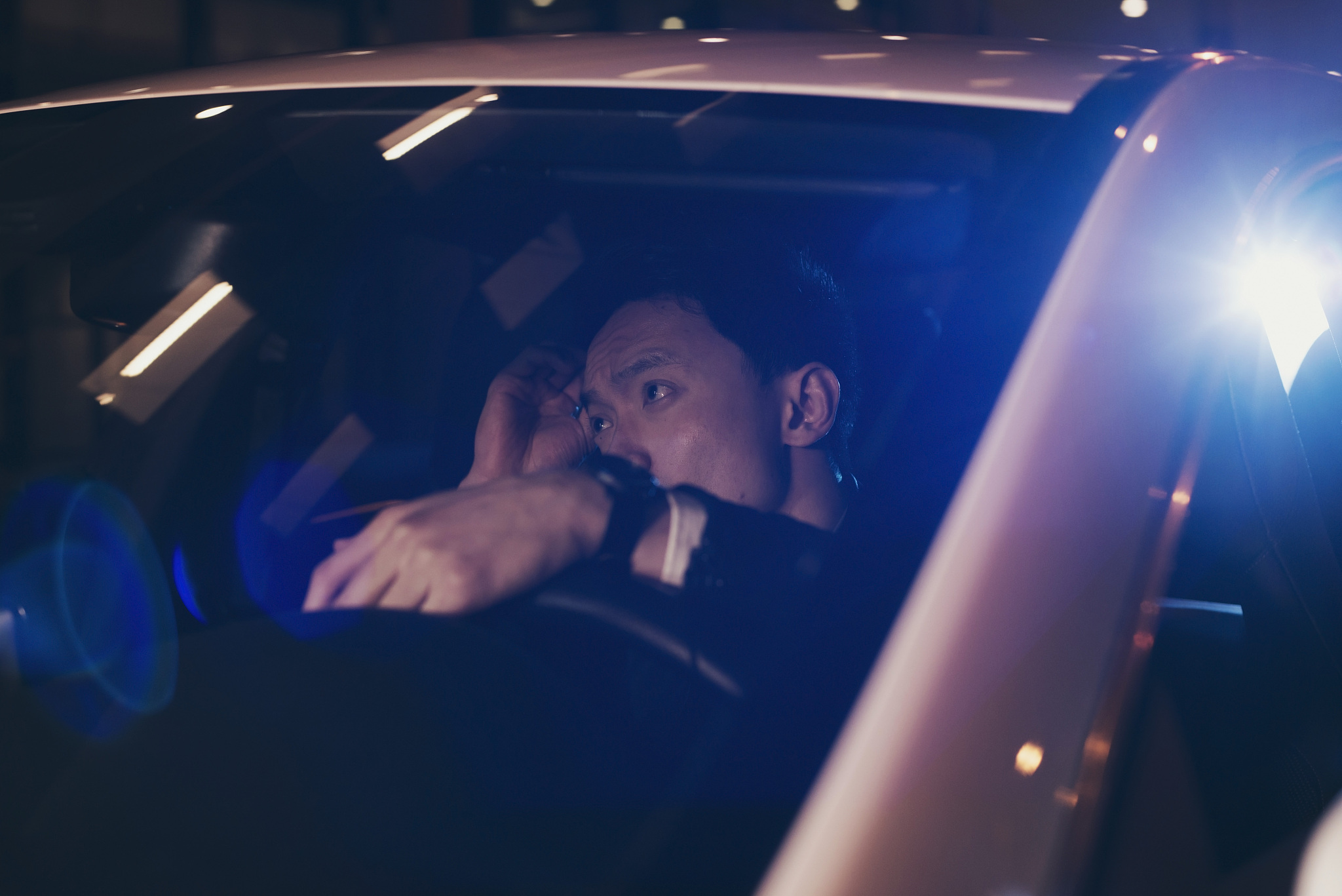 asian man in car doing his hair.
