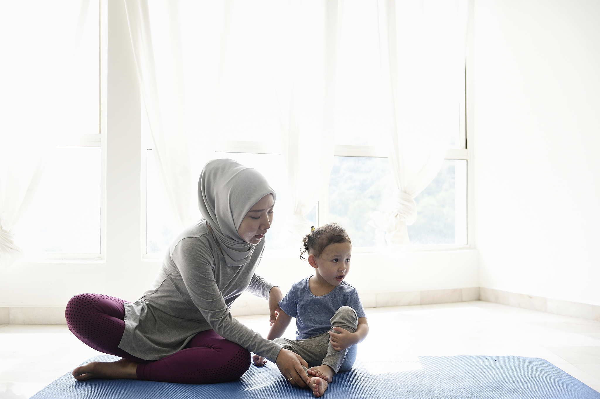 woman teaching her daughter yoga