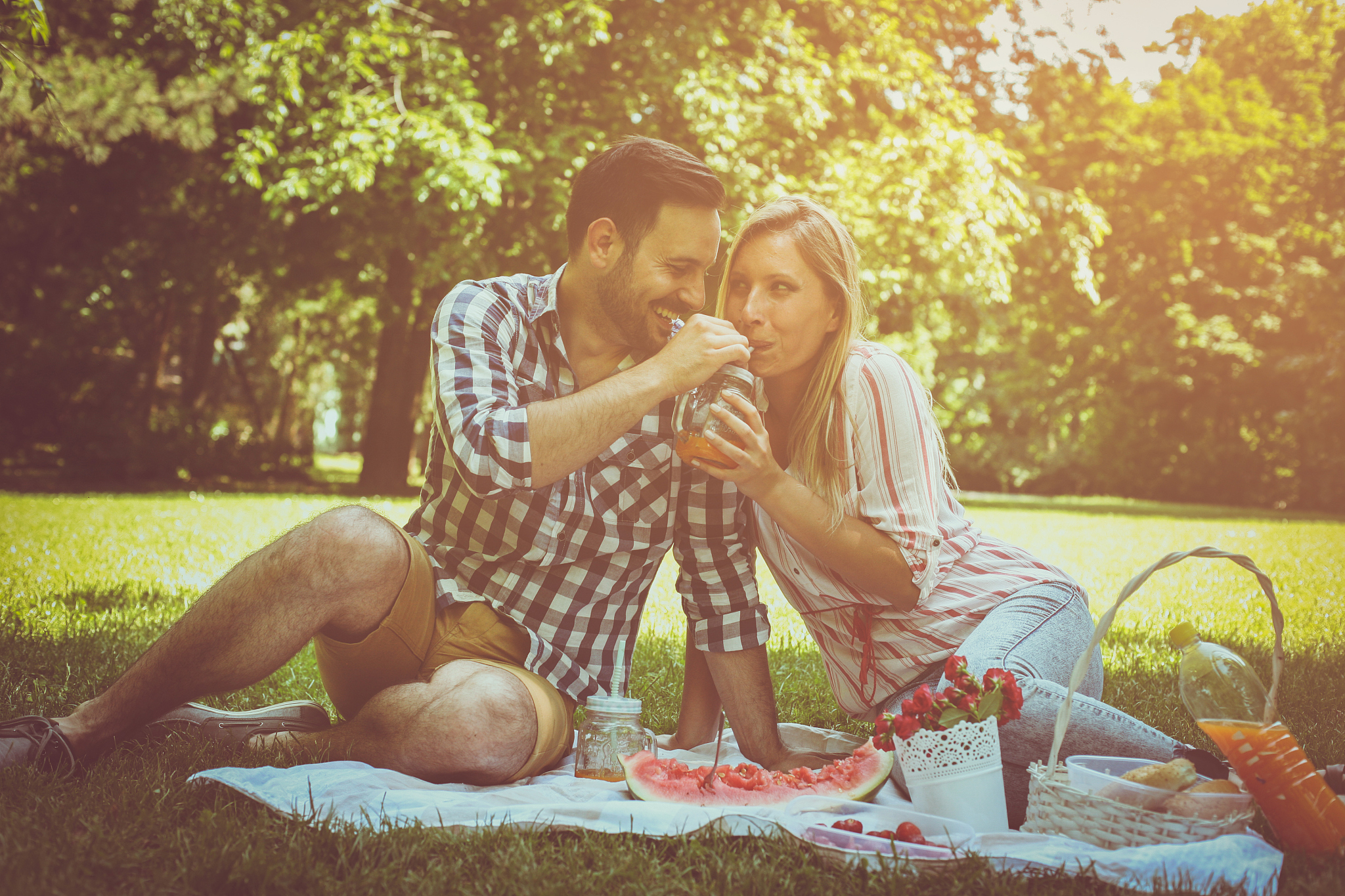 young happy couple having picnic in the meadow. couple sitting o