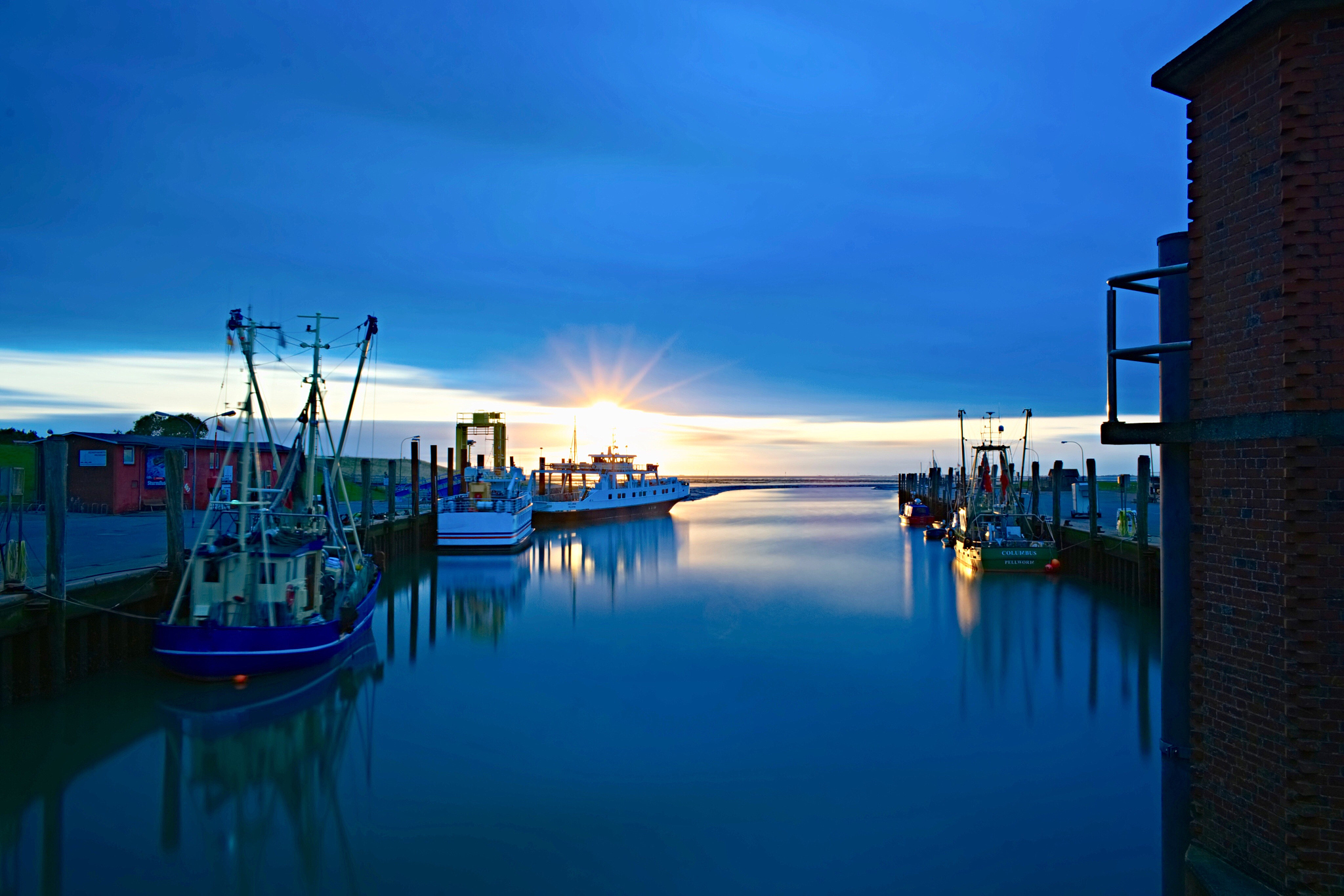 boats moored at harbor against sky during sunset