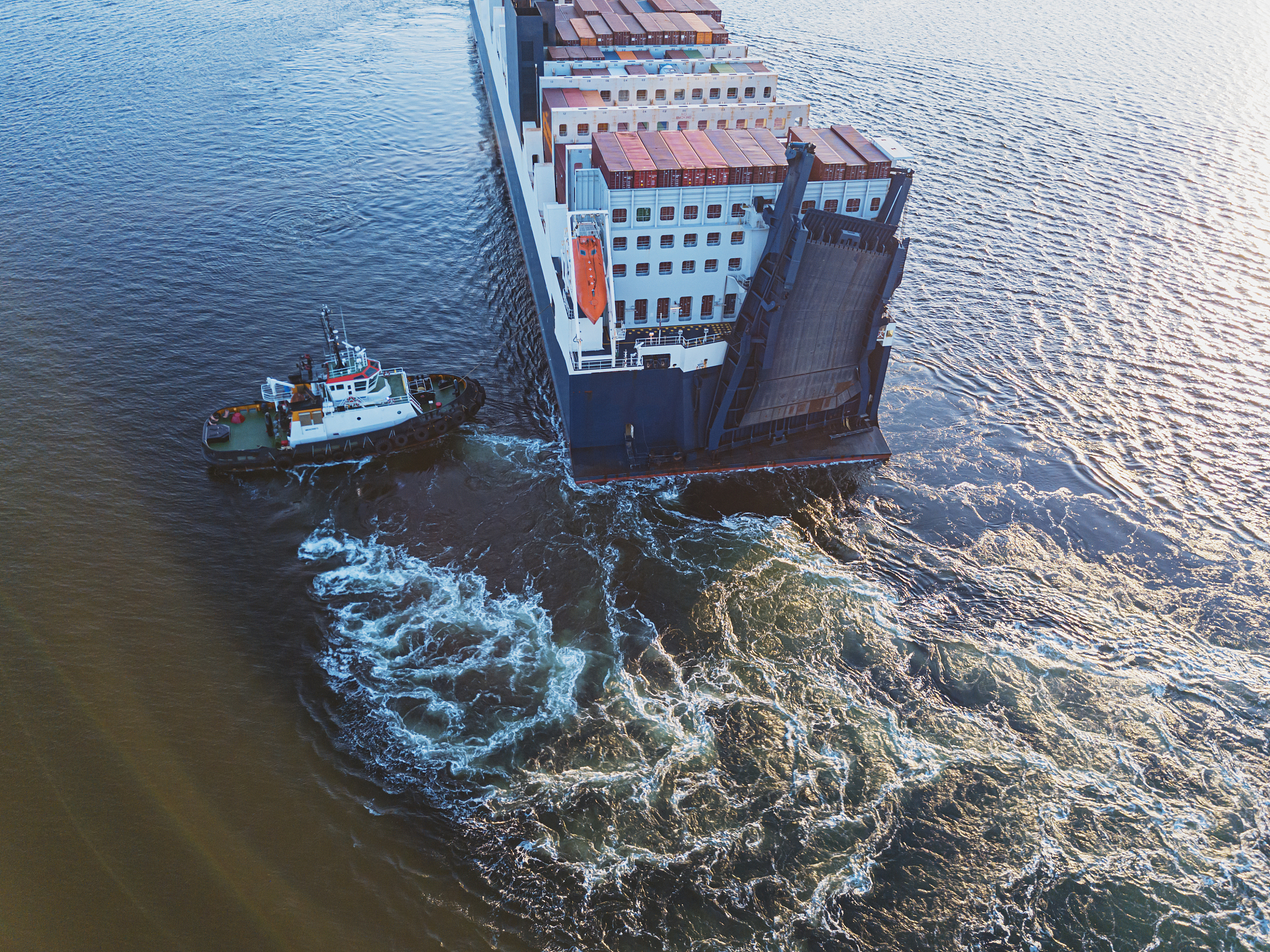 将【港口容纳船舶能力主要是指港口航道、码头水深、可利用岸线长度以及港口规模等。长江航道由于地理条件的限制越靠近上游的地区可通过的船舶吨位越小而由于集装箱班轮是定线、定班、定时服务不应受到枯水期的影响因此对港口航道、码头水深条件的要求较高。】换一种方式表达意思不改变