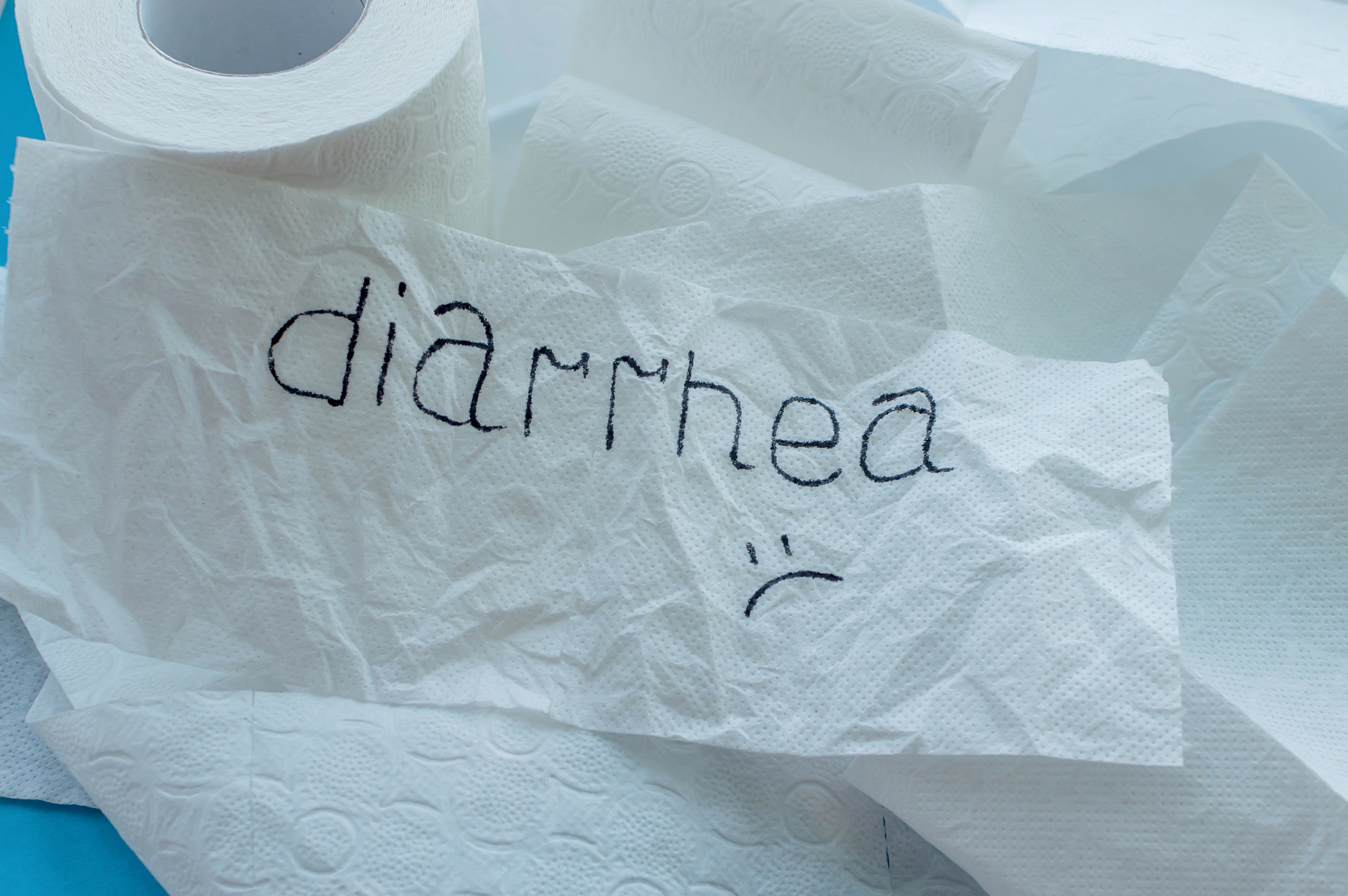 rolls of white toilet paper labeled "diarrhea" on a blue backgro