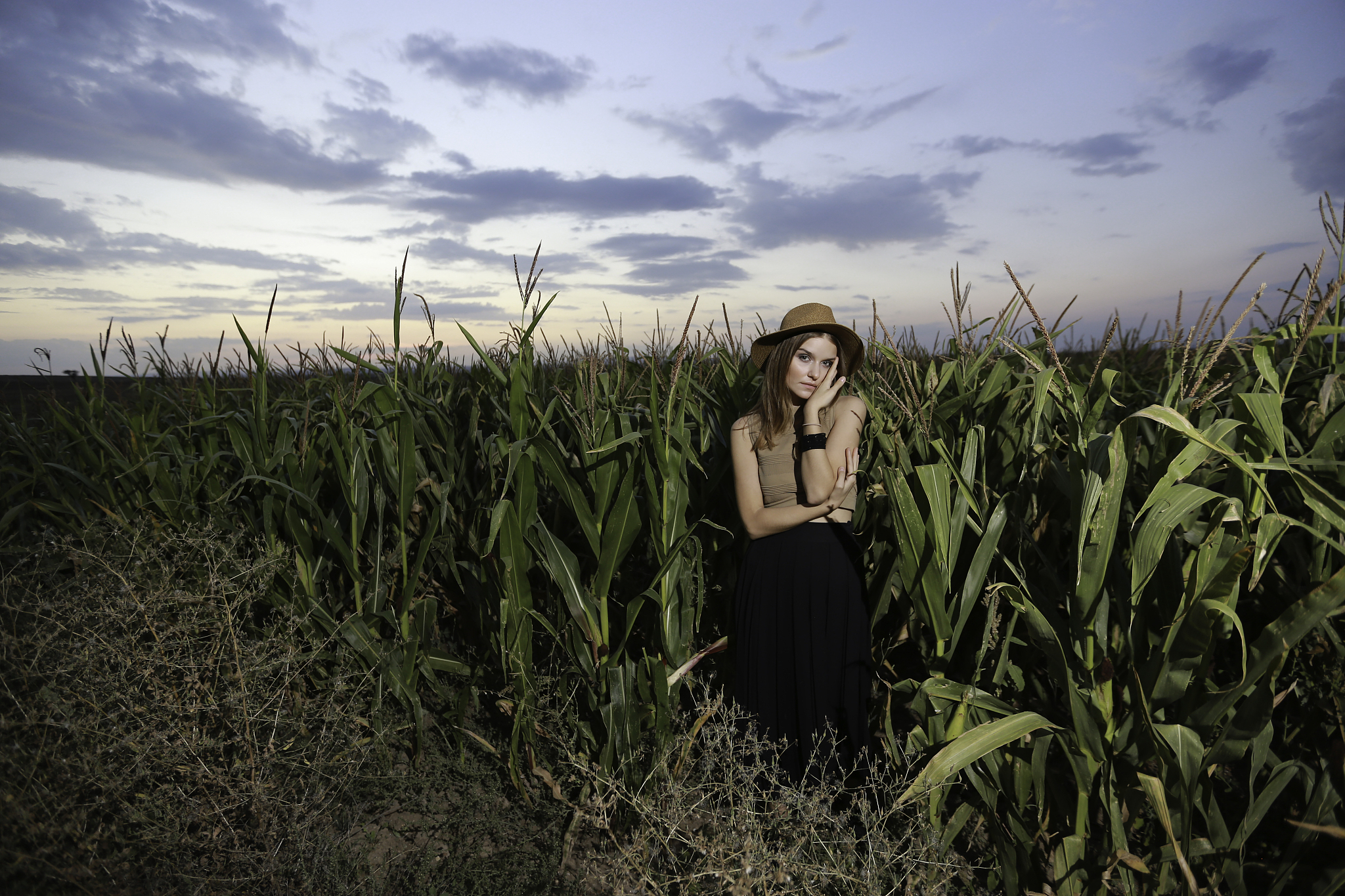 young beautiful woman stands in a dress among ripe corn. agrocul