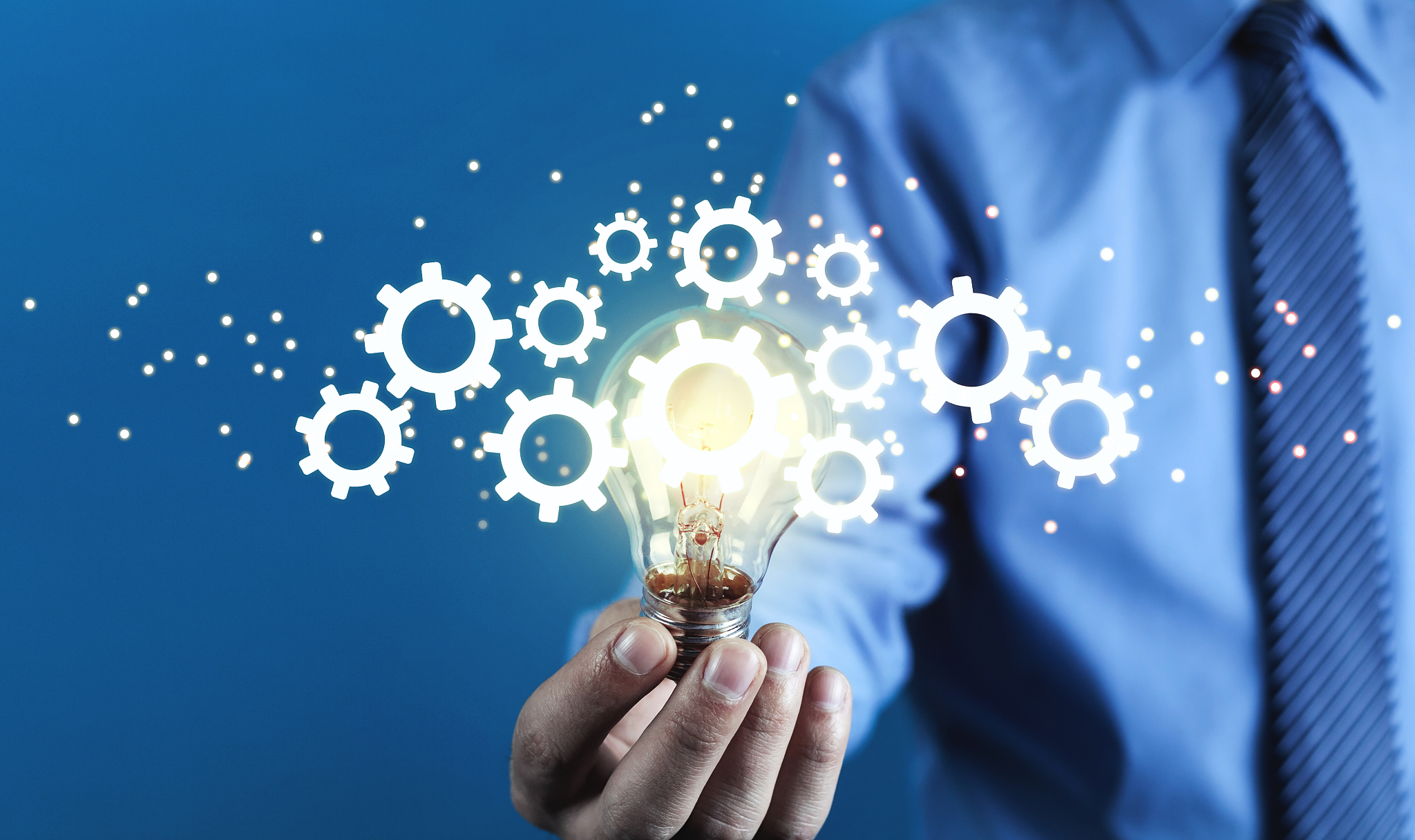 man holding light bulb and gears mechanism. concept of idea, ima