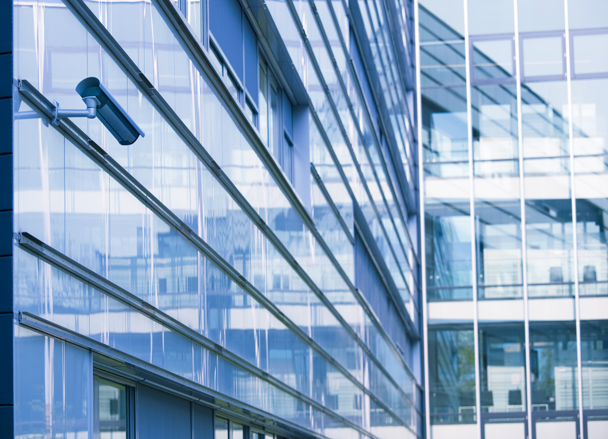 surveillance camera on glass facade