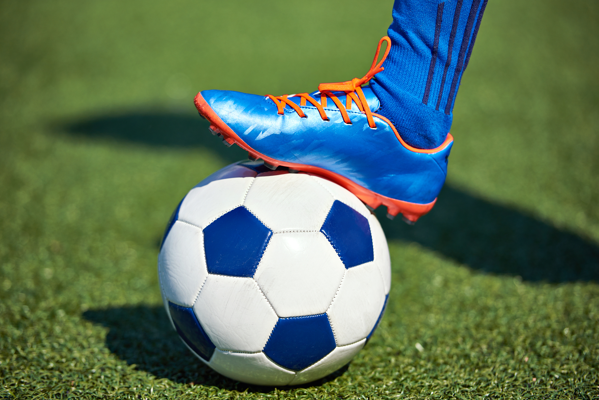 foot of soccer player in football boot on ball