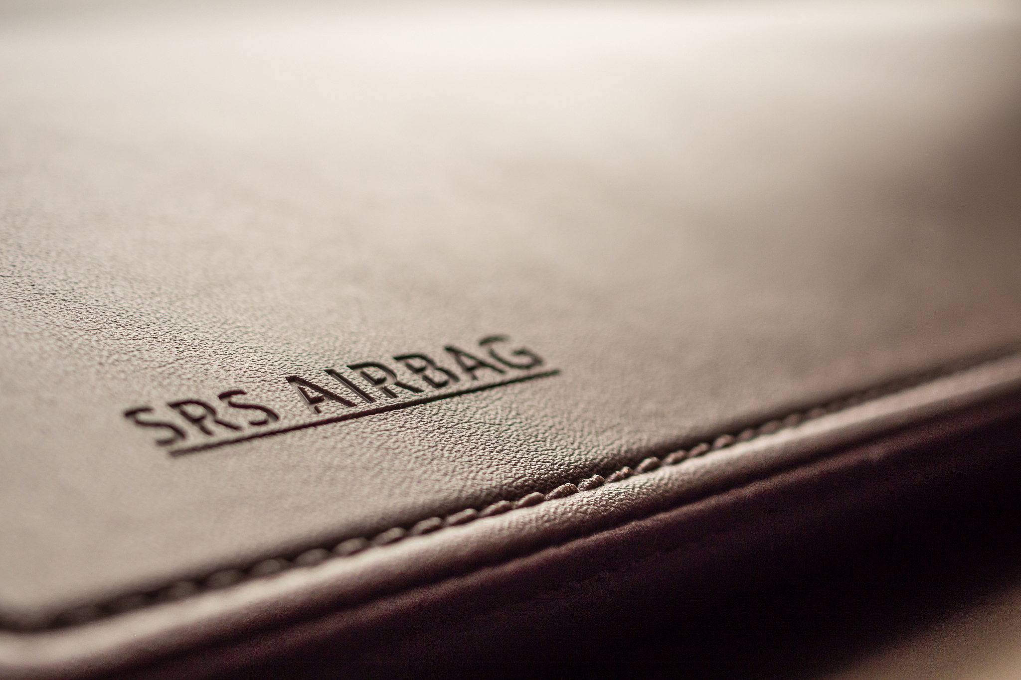 airbag safety sign on brown leather texture in modern car