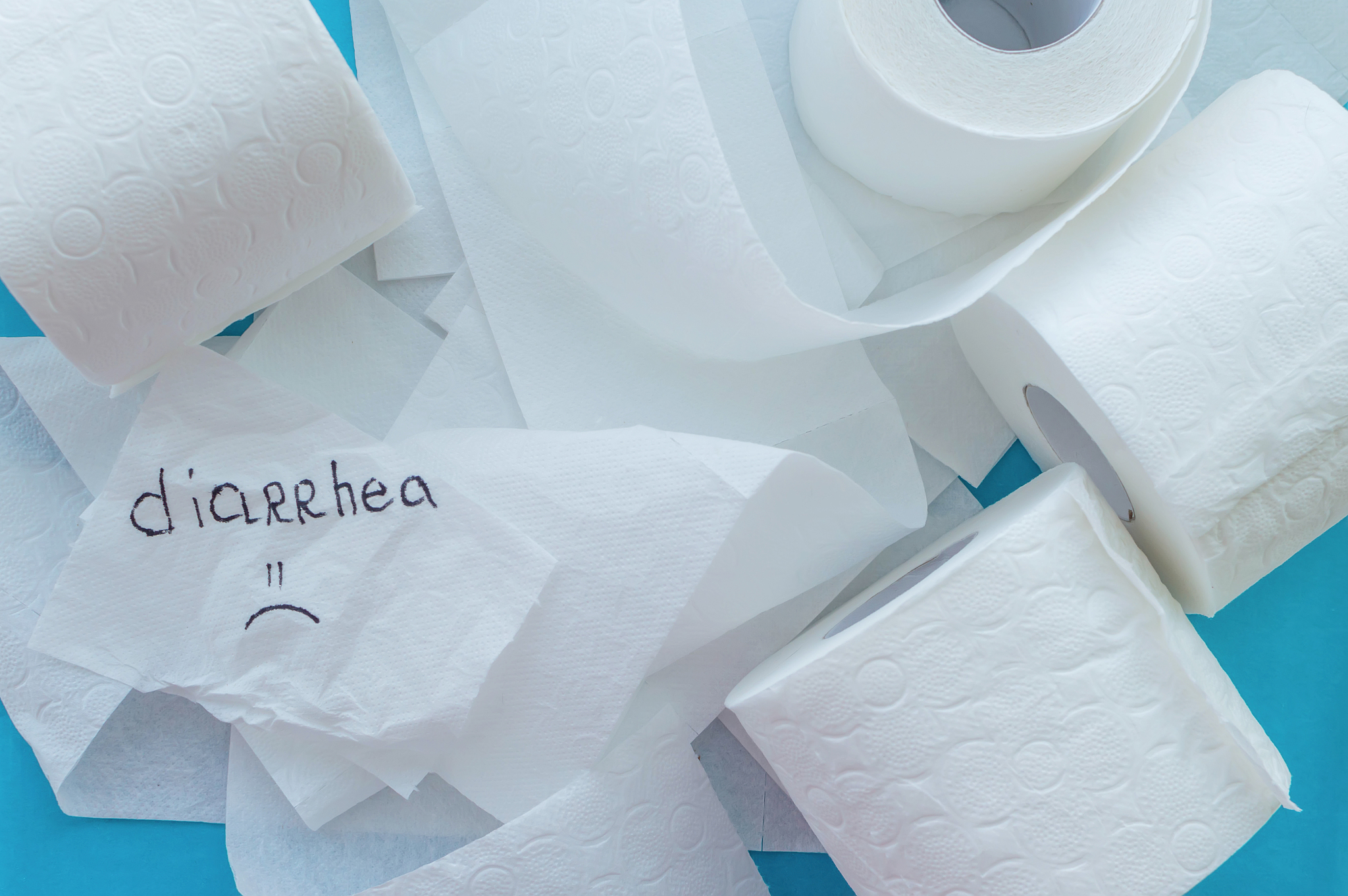 rolls of white toilet paper labeled "diarrhea" on a blue backgro