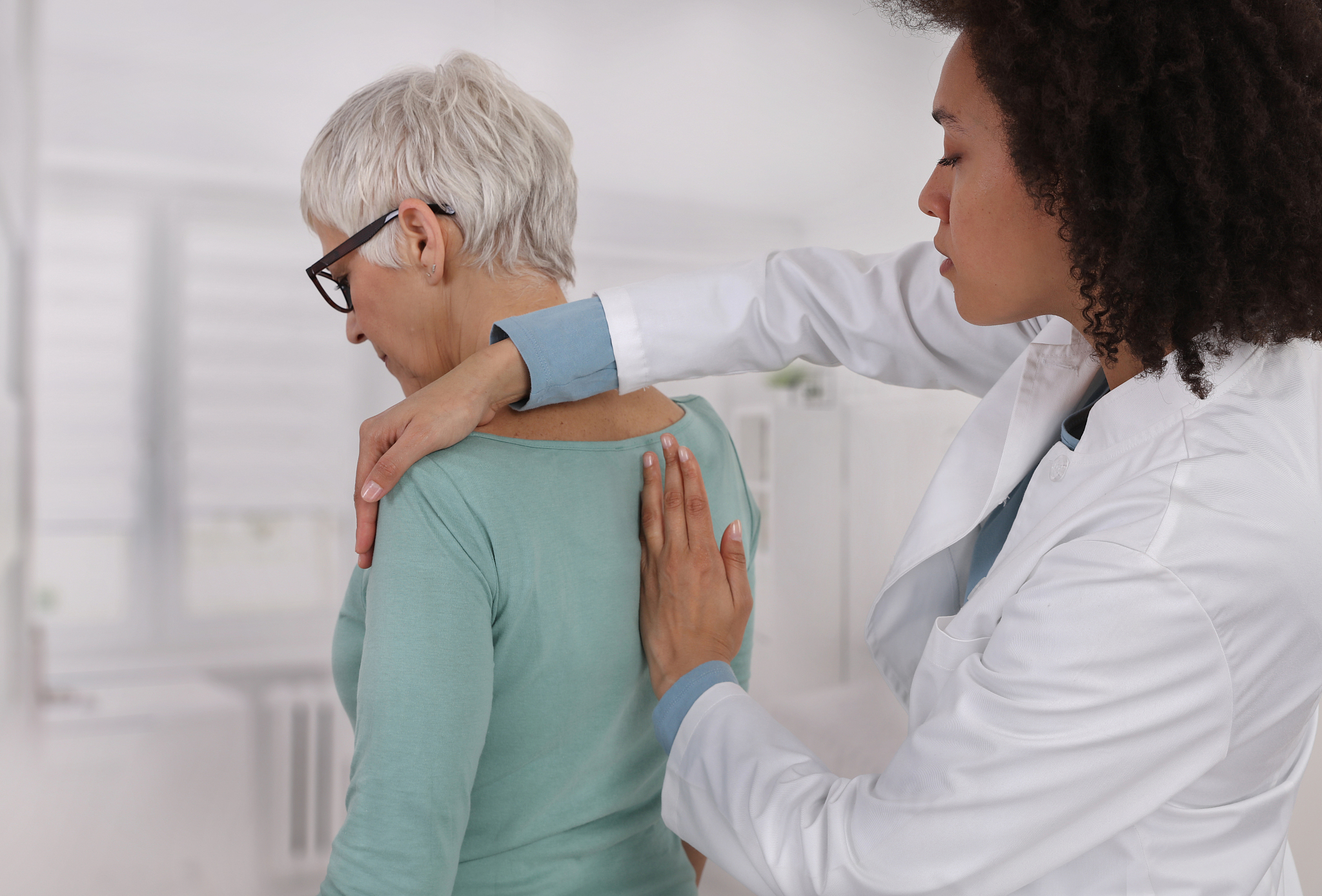 mature woman having chiropractic back adjustment. osteopathy, ph