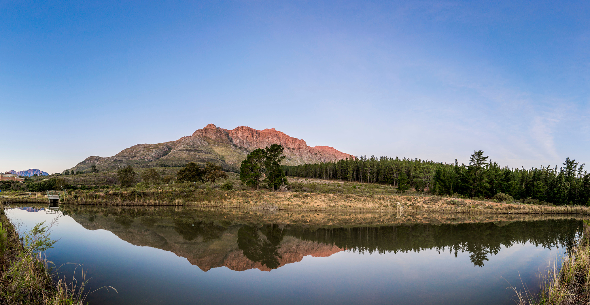 scenic view of lake by mountains against clear sky