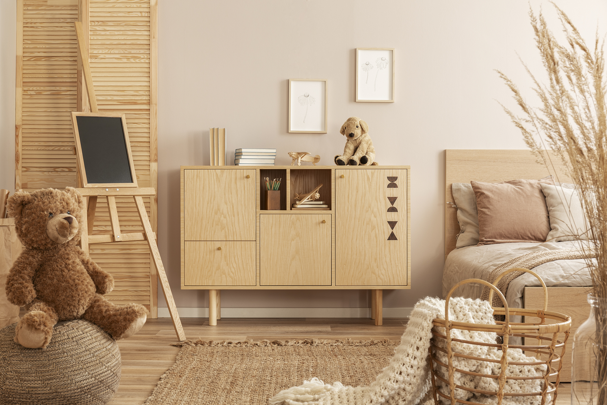 teddy bear on pouf and small blackboard on easel in stylish kid'