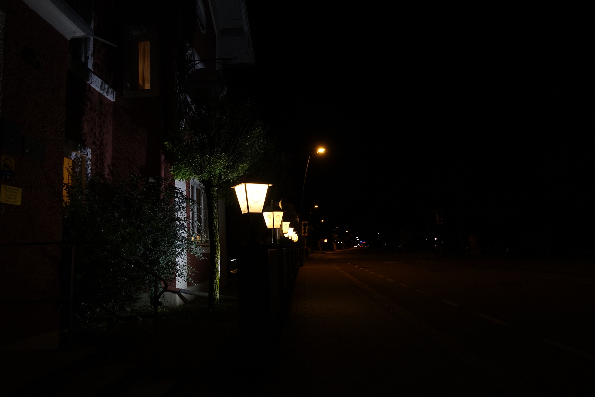 illuminated street light in city against sky at night