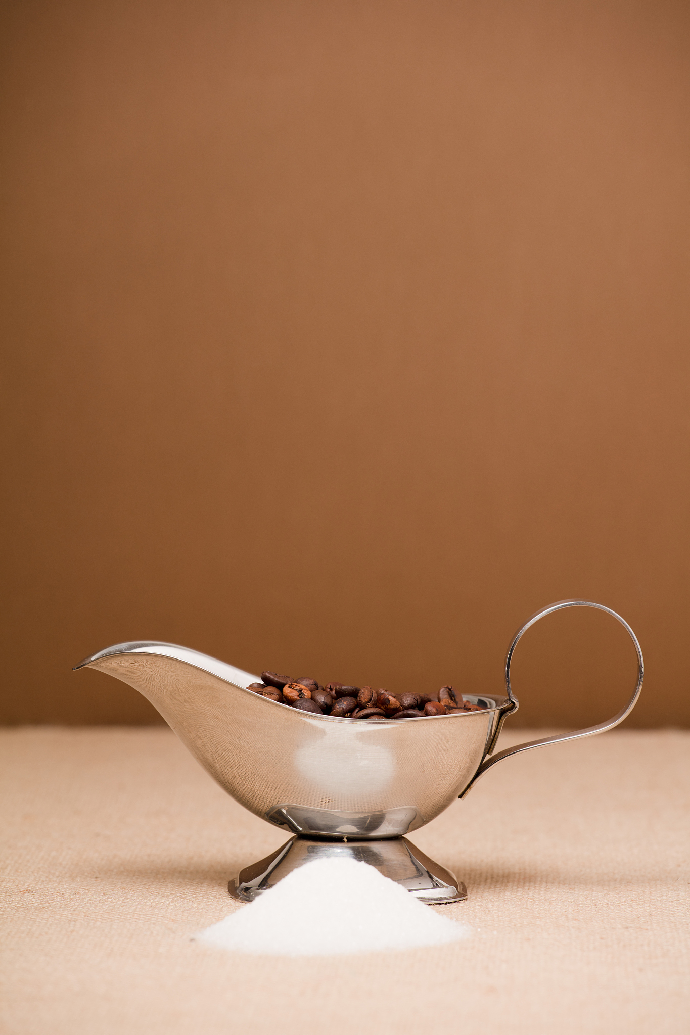 coffee in silver container, brown background