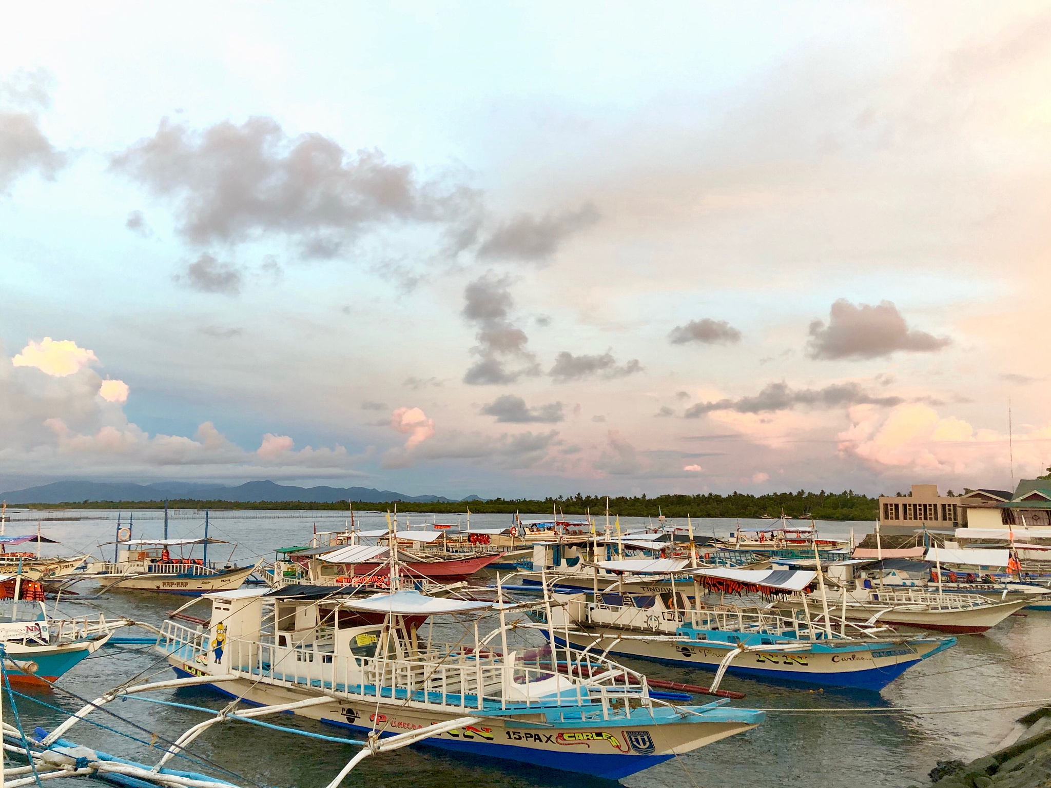 boats moored at harbor against sky during sunset