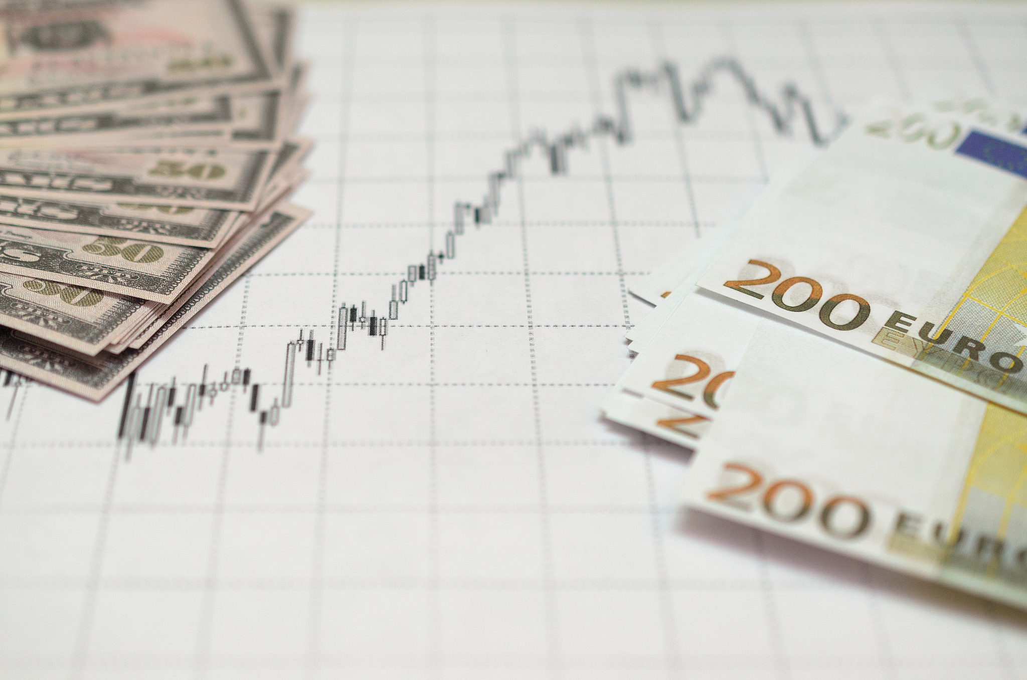 money against the background of financial stock charts.
