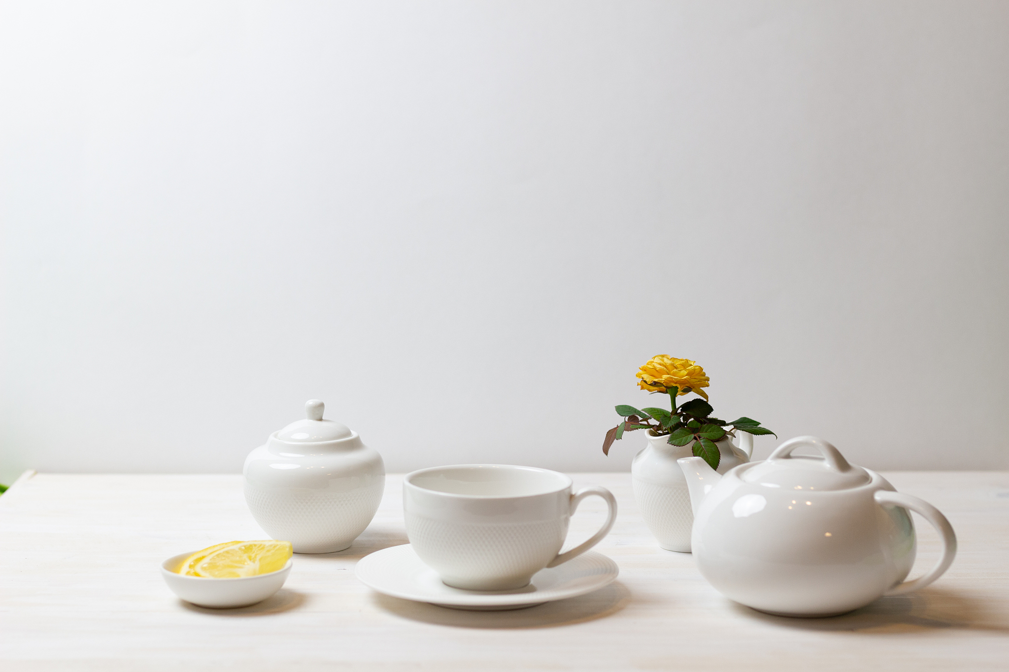 tea in cup with saucer, teapot, sugar bowl, yellow rose in milk 