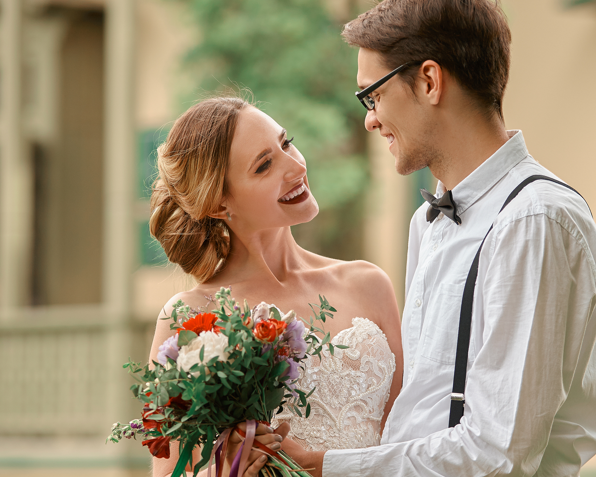happy bride and groom against their new home