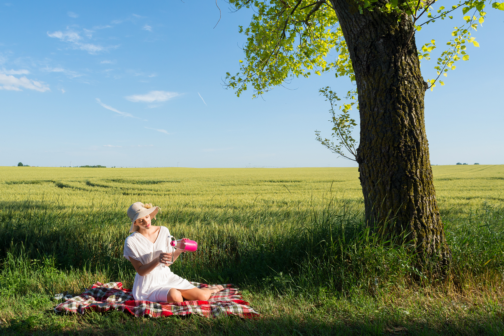 在广阔的草原上一个可爱的女孩在雨中拿着伞探索奔跑