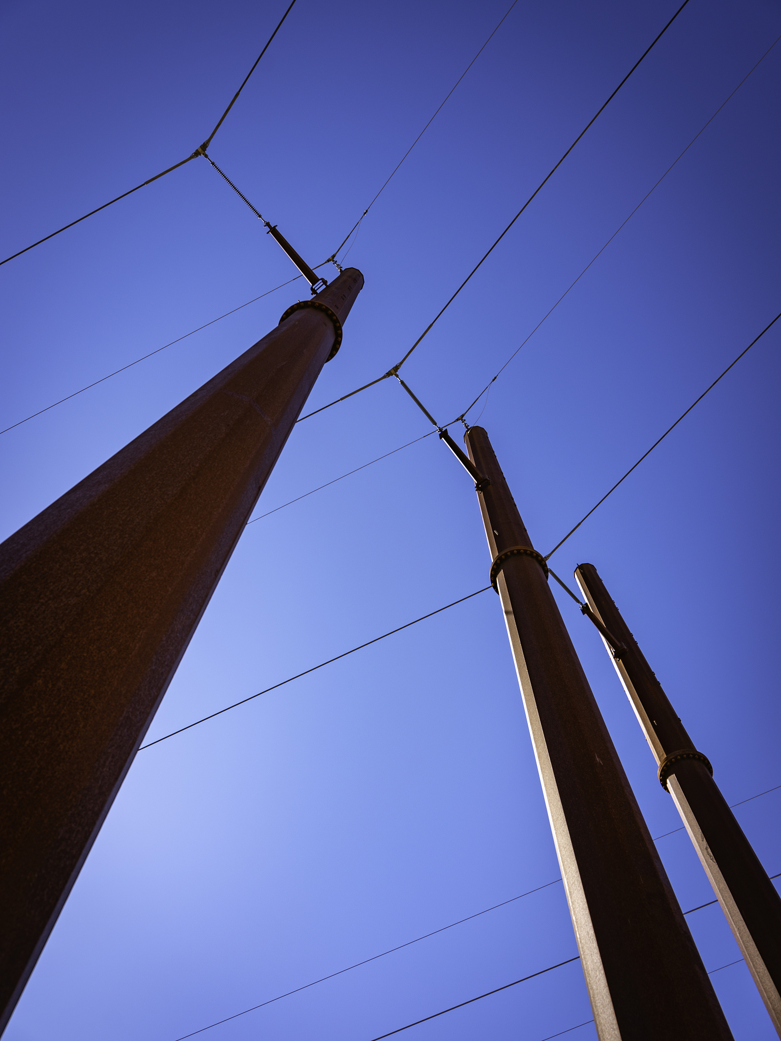 让以下文字变得通顺：呃那他这里面又带了一个问题为什么选择这么个区域拍这些照片呢？我觉得就像他选择拍比萨斜塔他可能会觉得这些本身这个电线杆的歪扭增强了他想表达这个28mm镜头下世界的歪扭