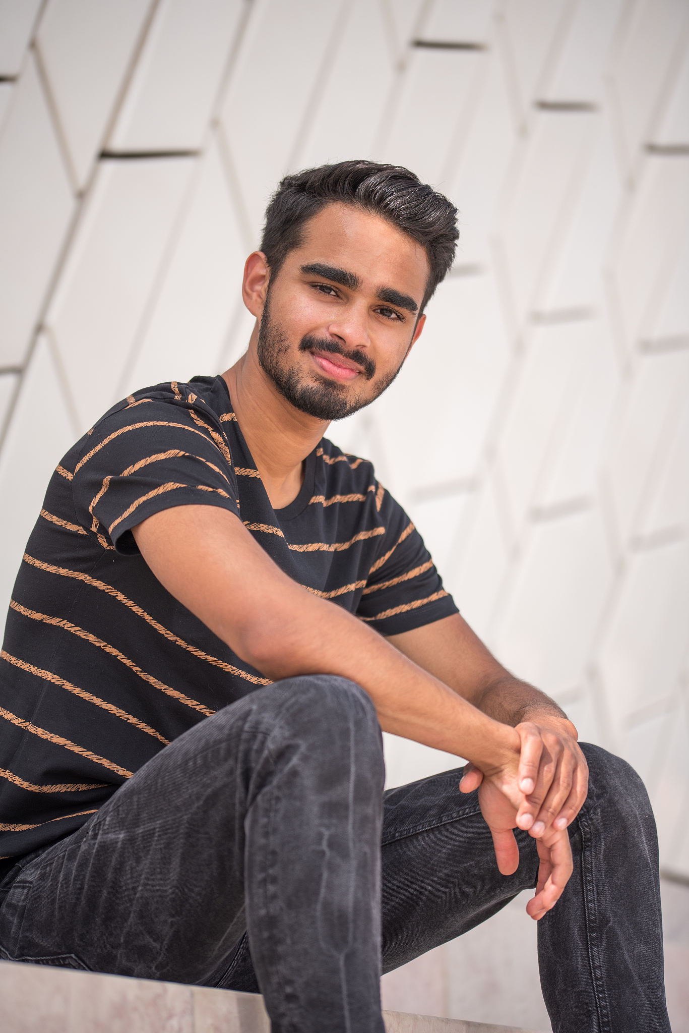 male model posing in font of white modern building