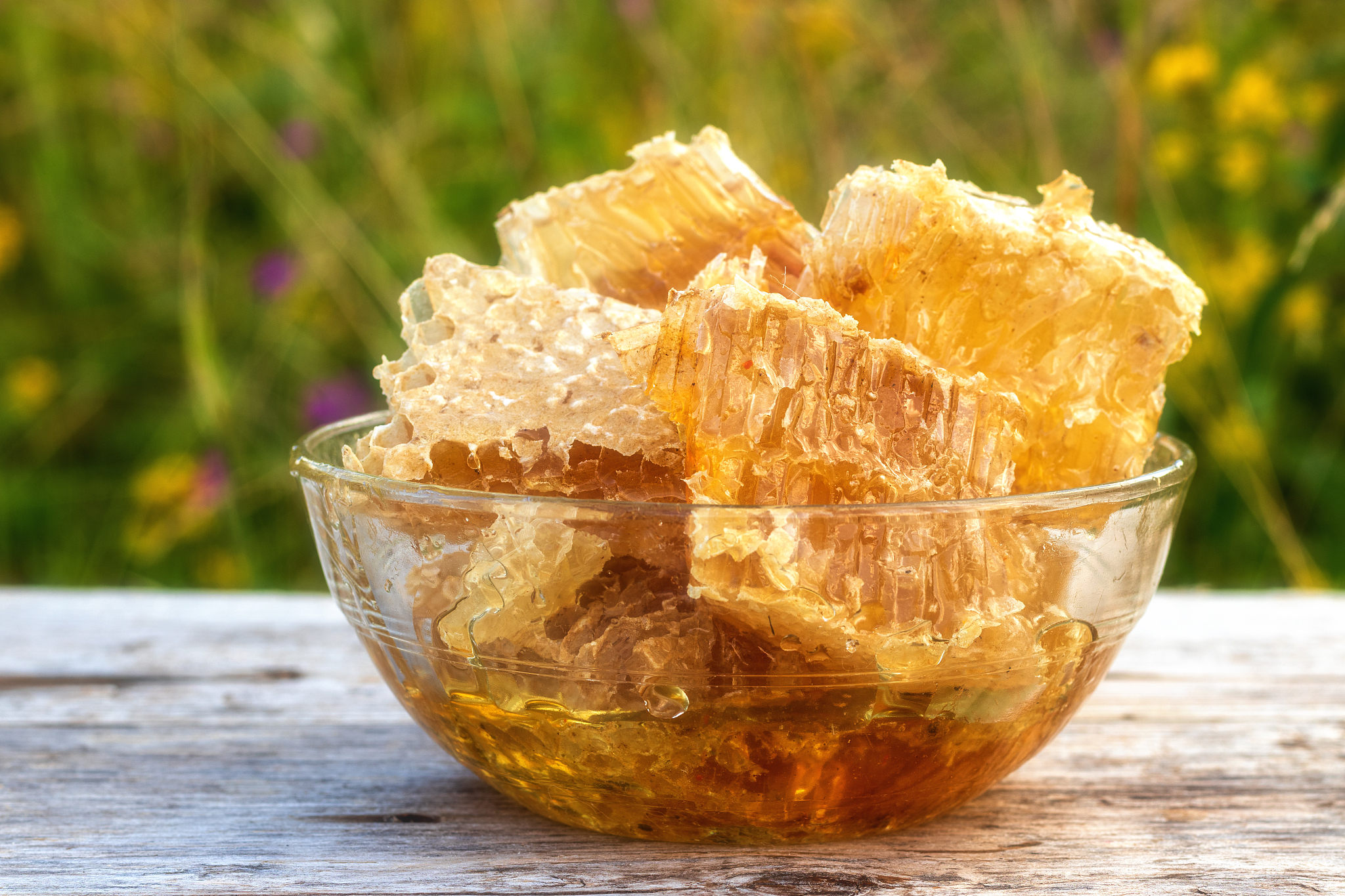 honeycomb with golden honey in a glass bowl