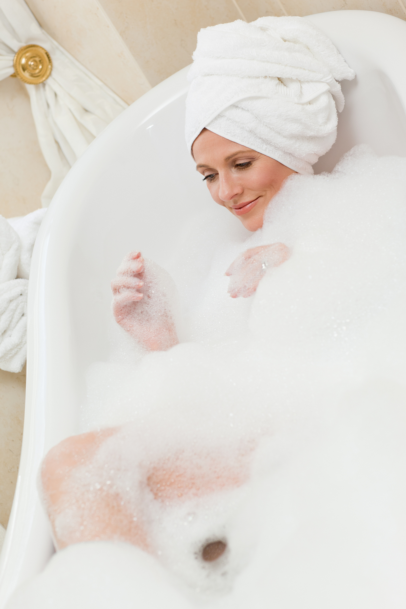 lovely woman taking a bath with a towel on her head