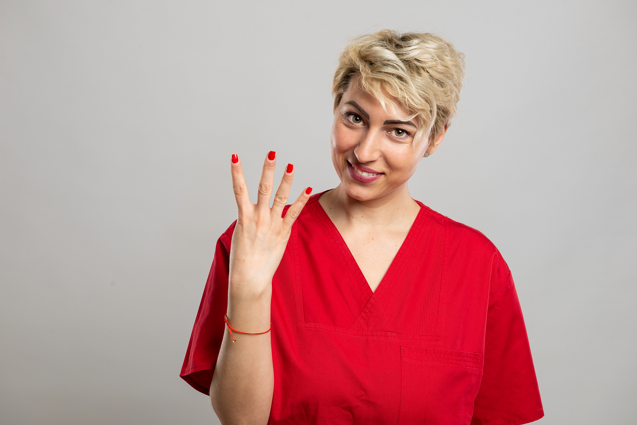 portrait of young attractive female nurse showing number four